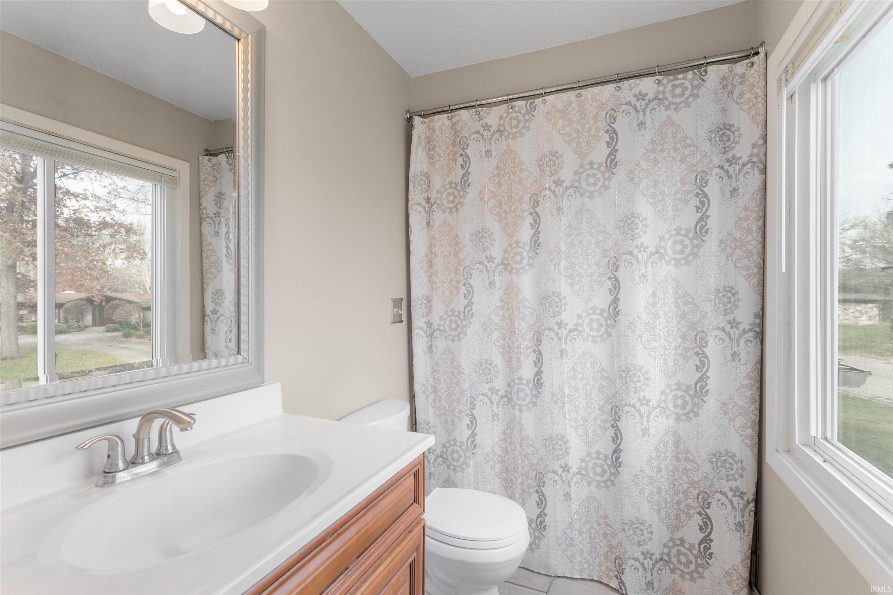 Full bathroom featuring plenty of natural light, vanity, and a shower with curtain