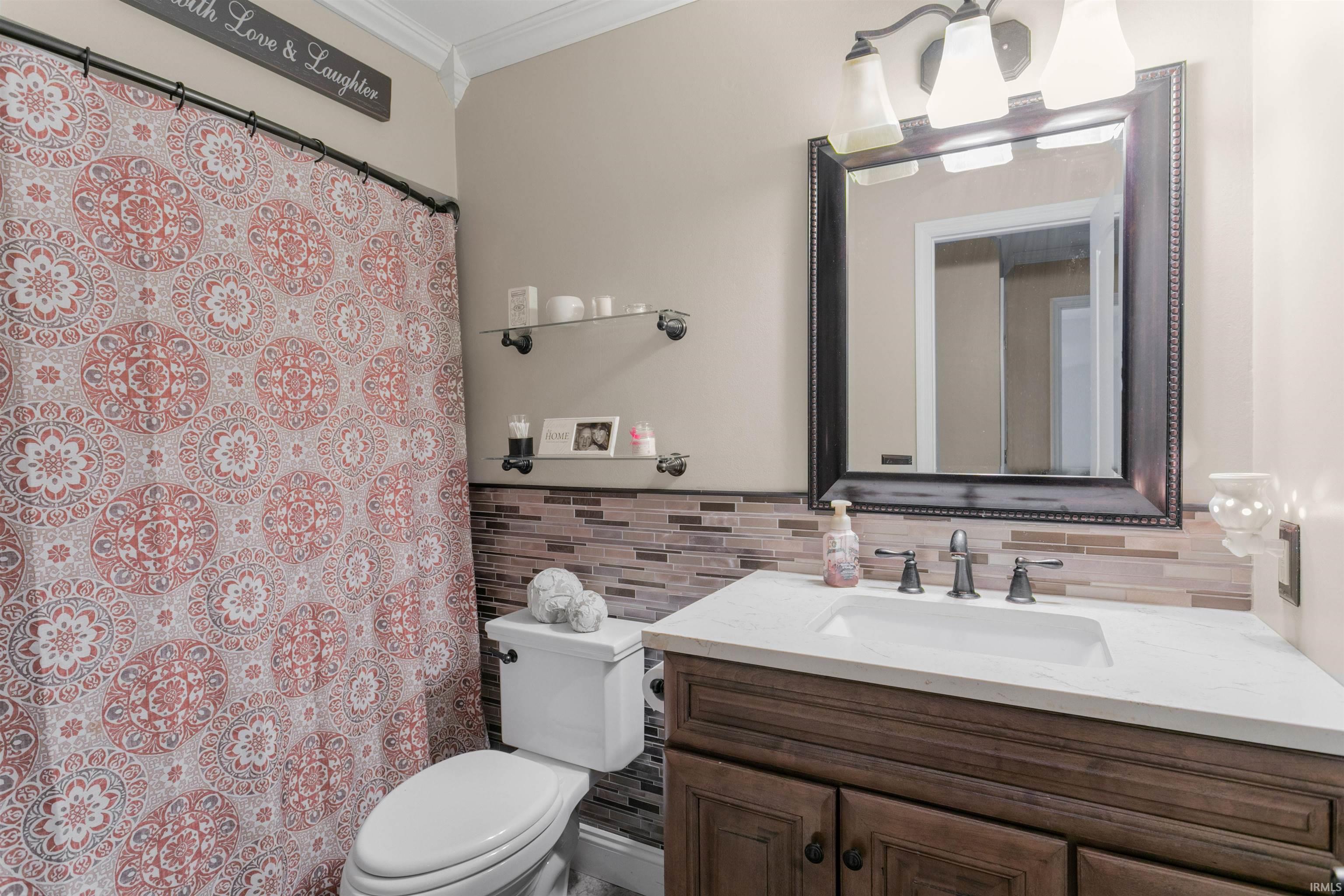 Bathroom featuring vanity, a shower with curtain, and ornamental molding