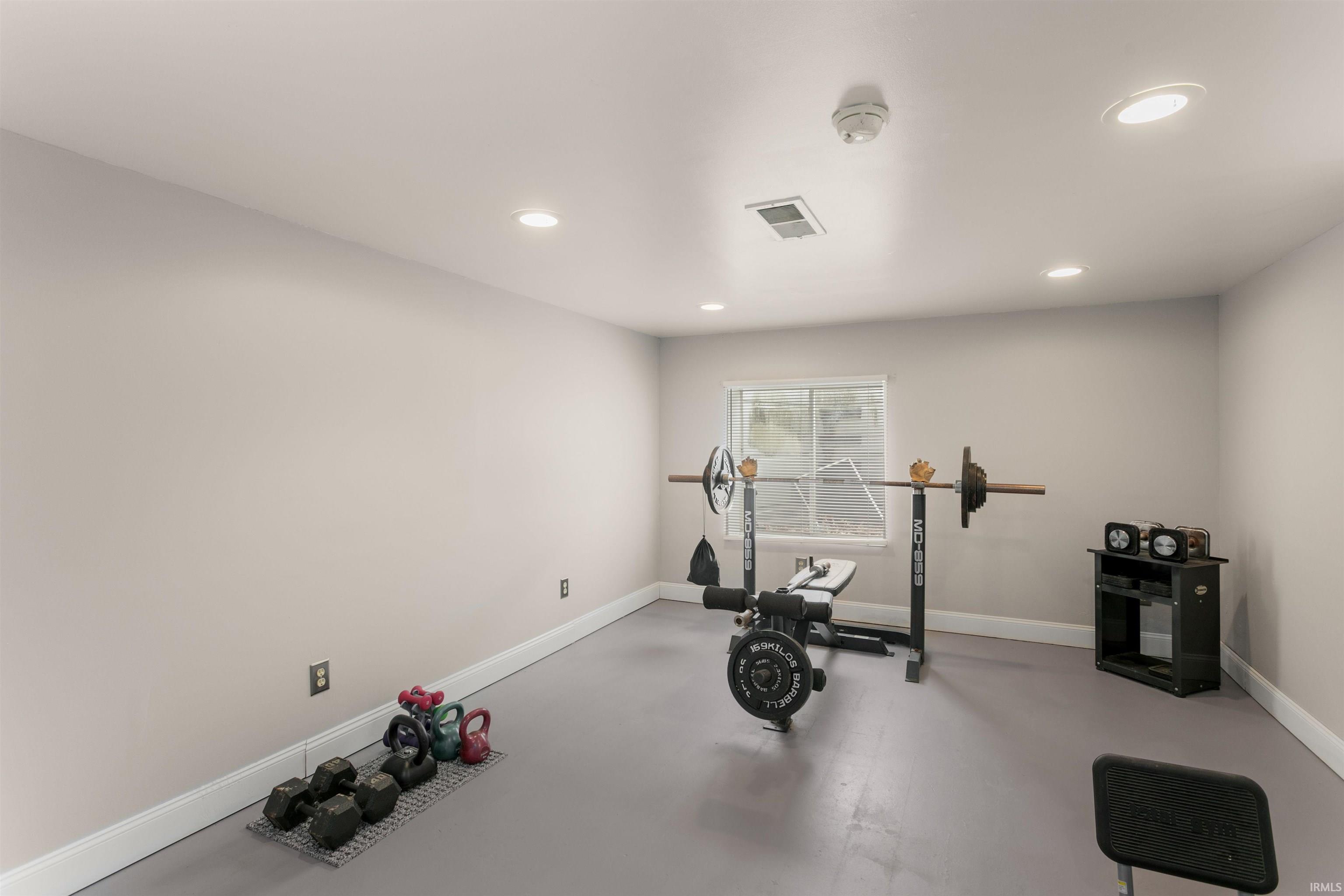 Exercise room with recessed lighting and finished concrete flooring