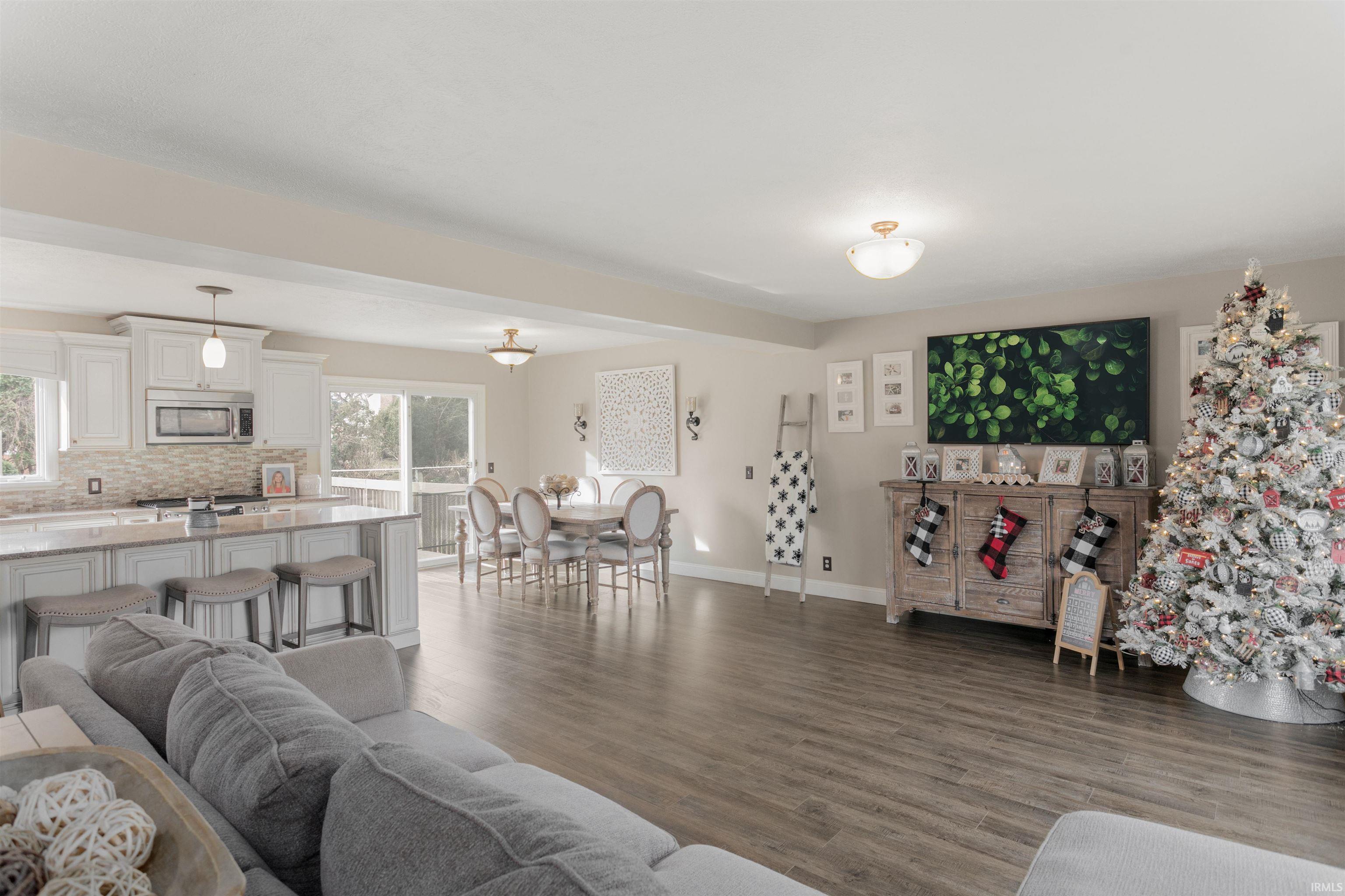 Living area with dark wood-type flooring and healthy amount of natural light