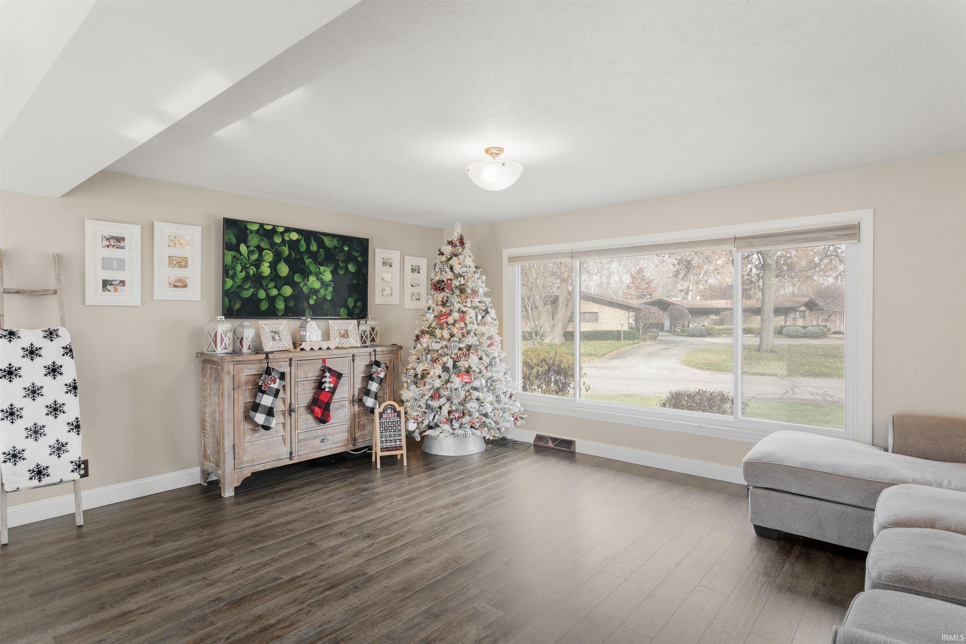 Living area with baseboards and dark wood-type flooring