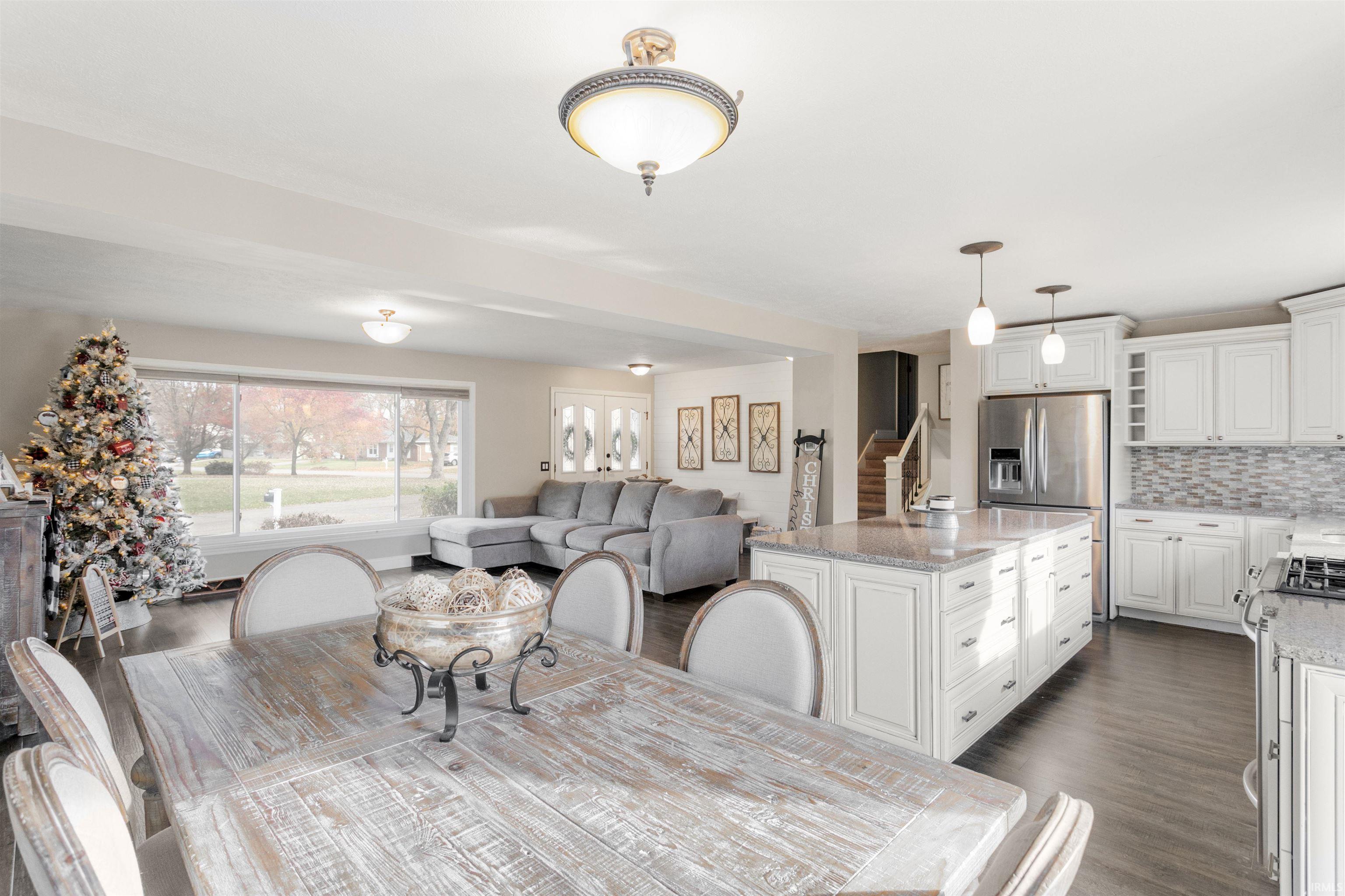 Dining space featuring stairs and dark wood-style flooring