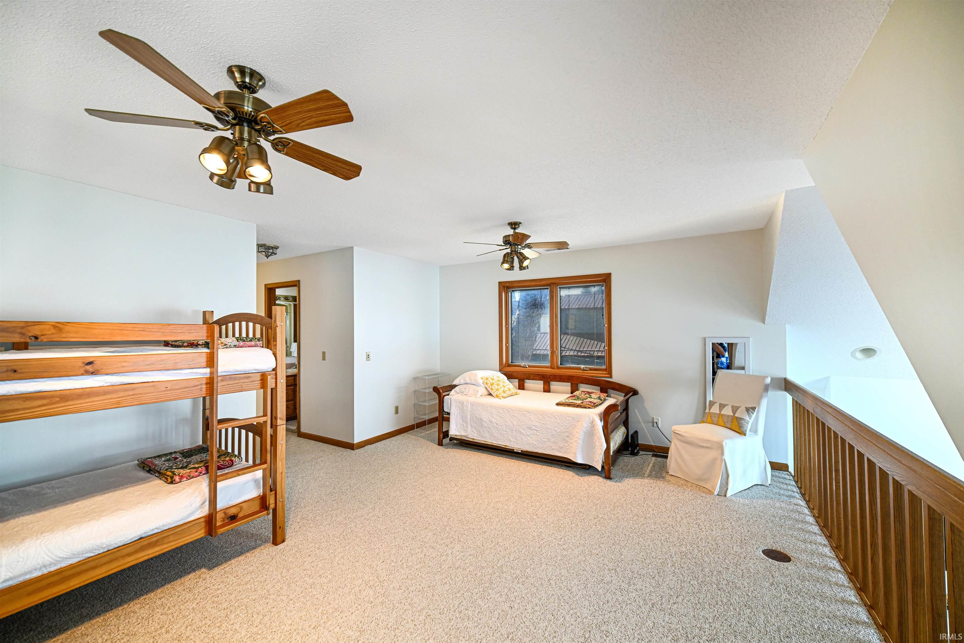 Carpeted bedroom with a ceiling fan and a textured ceiling