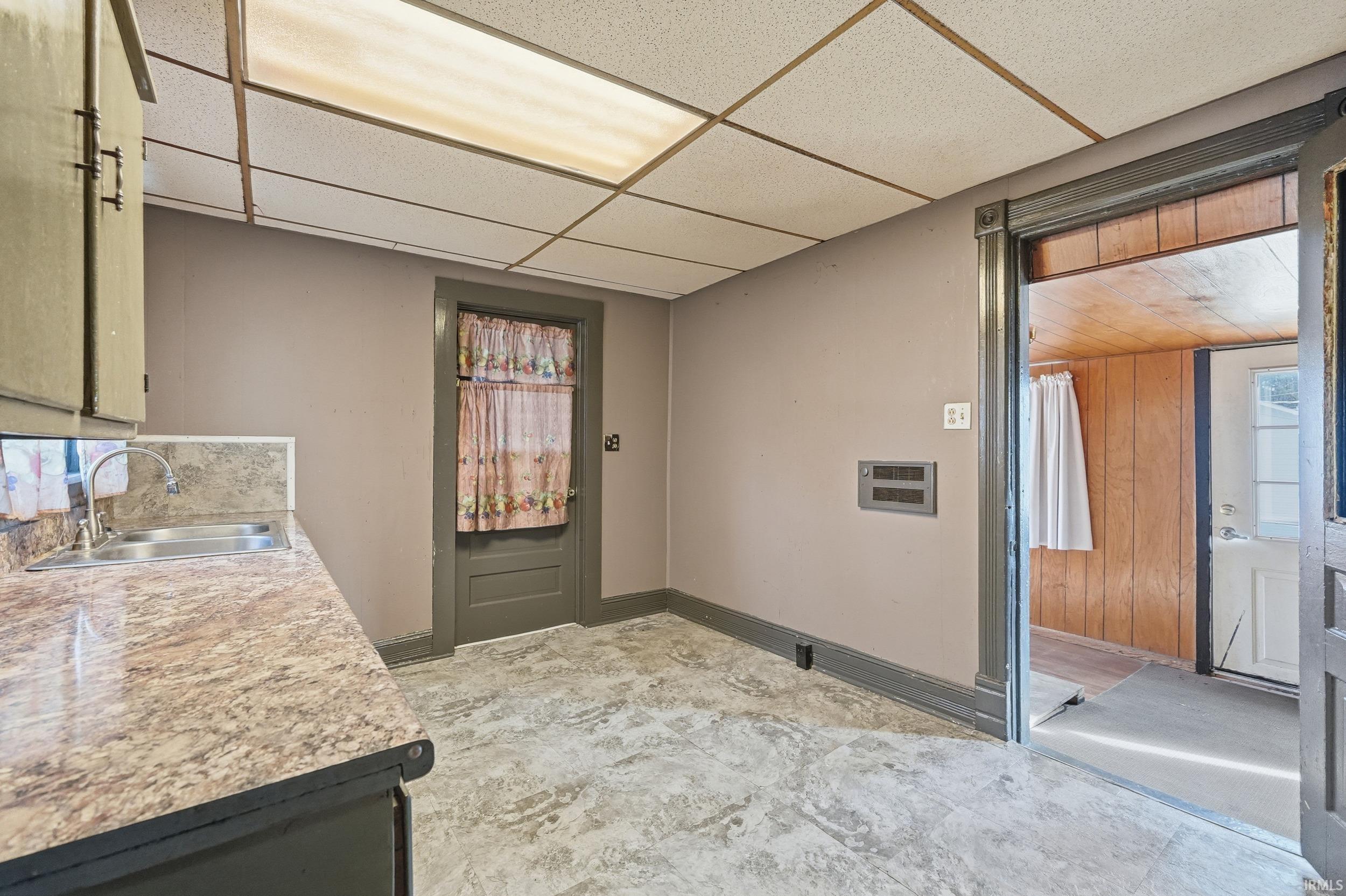 Laundry room with a drop ceiling and light flooring