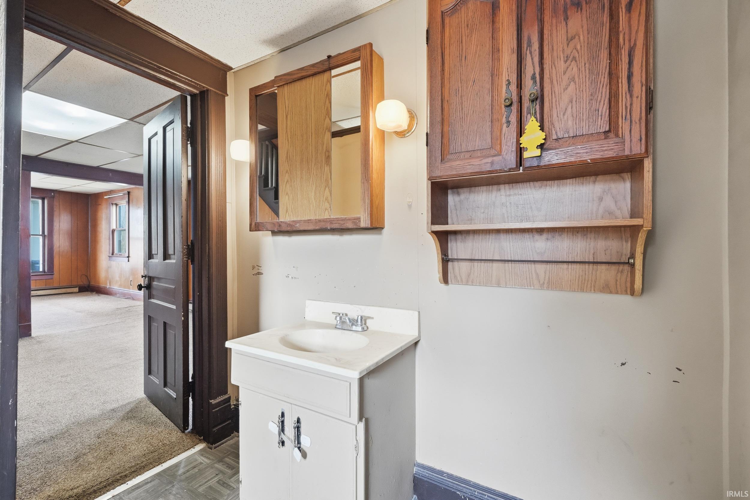 Bathroom with vanity, carpet, and a paneled ceiling