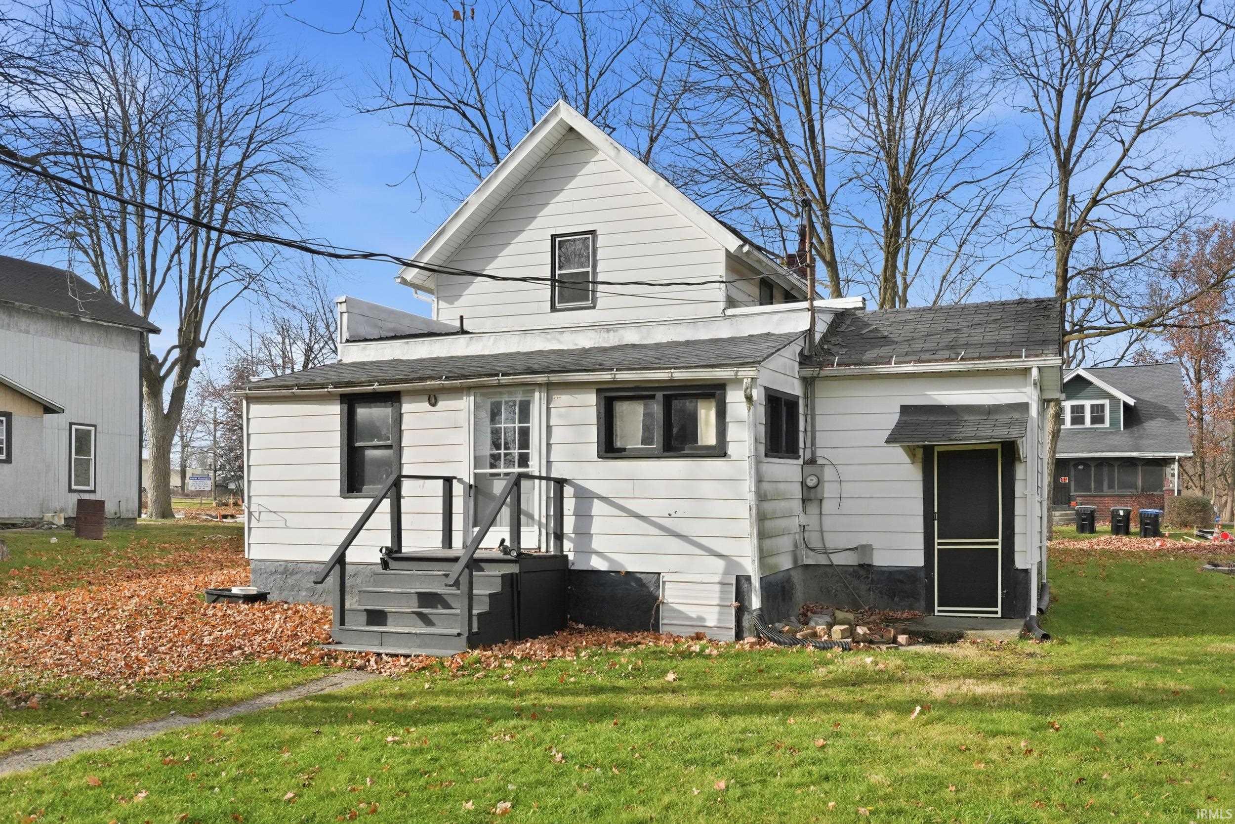 Rear view of property with a yard and a shingled roof