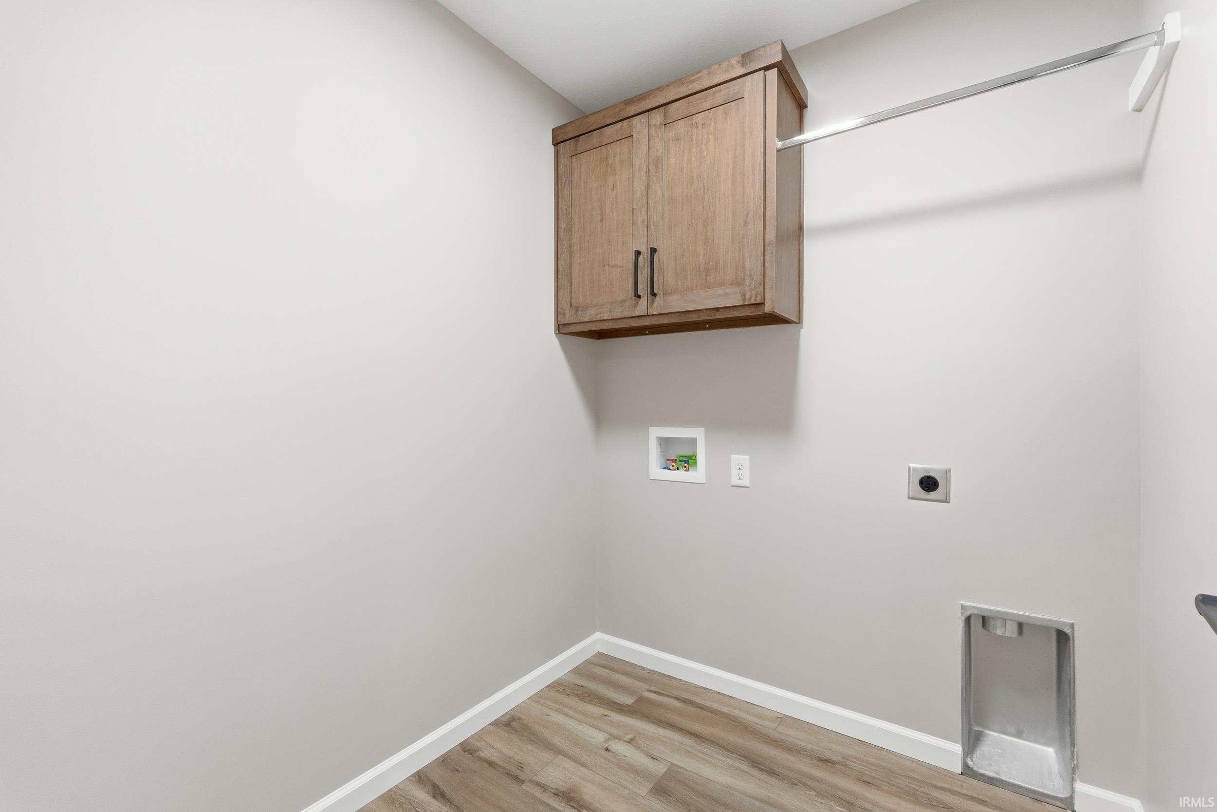 Laundry area featuring cabinet space, light wood-style floors, washer hookup, and hookup for an electric dryer