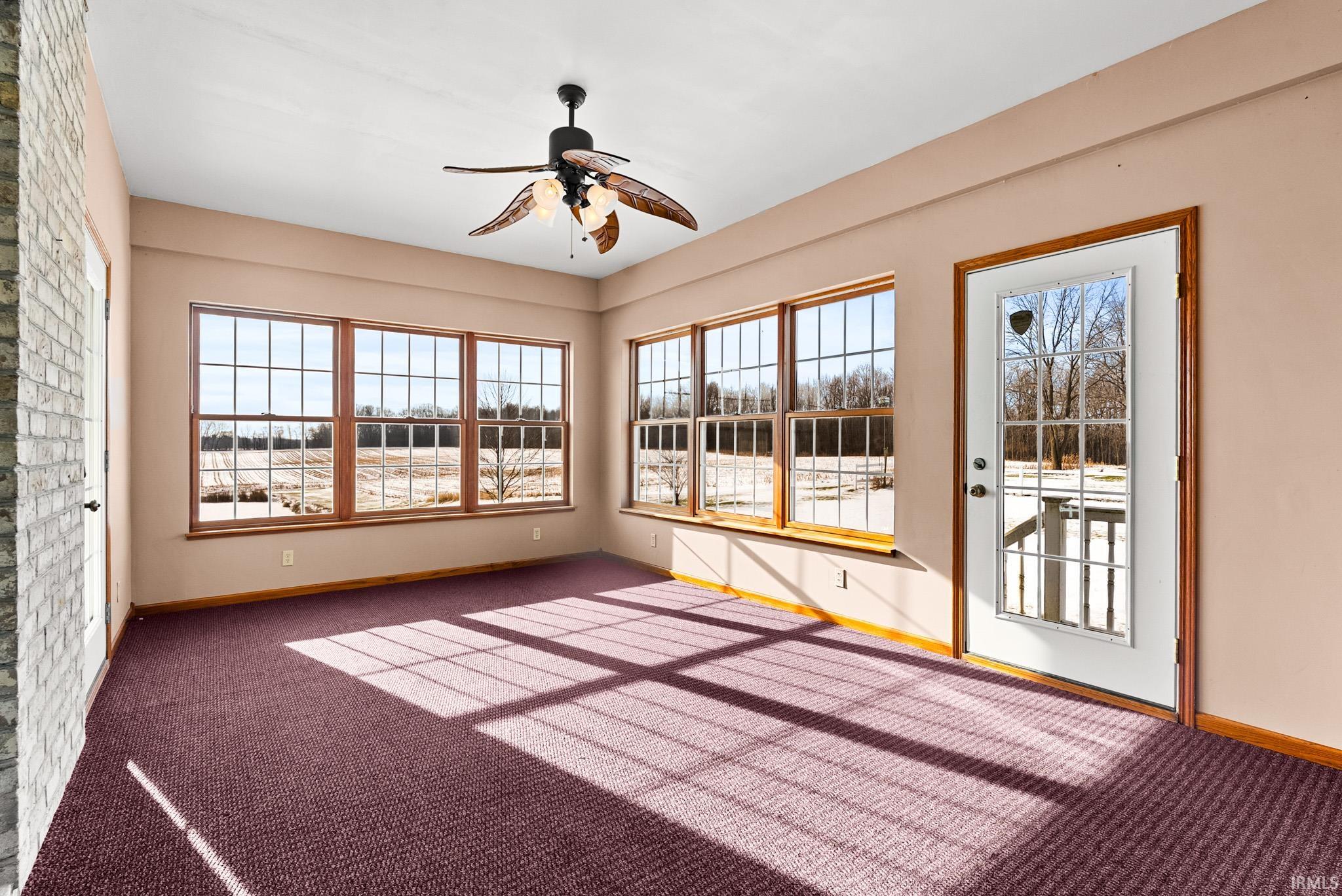 Unfurnished sunroom with carpet floors and healthy amount of natural light