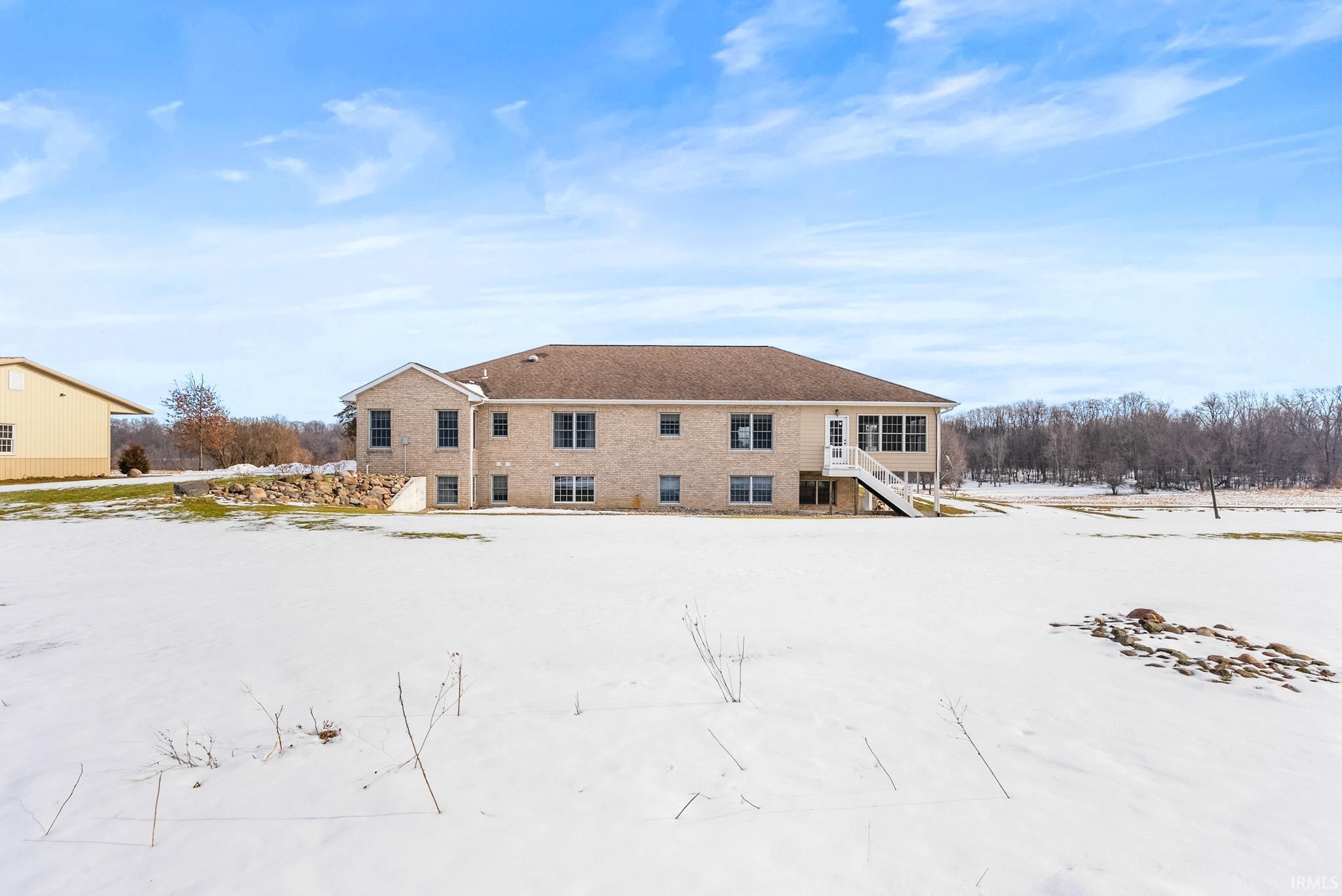 Snow covered property with stairs