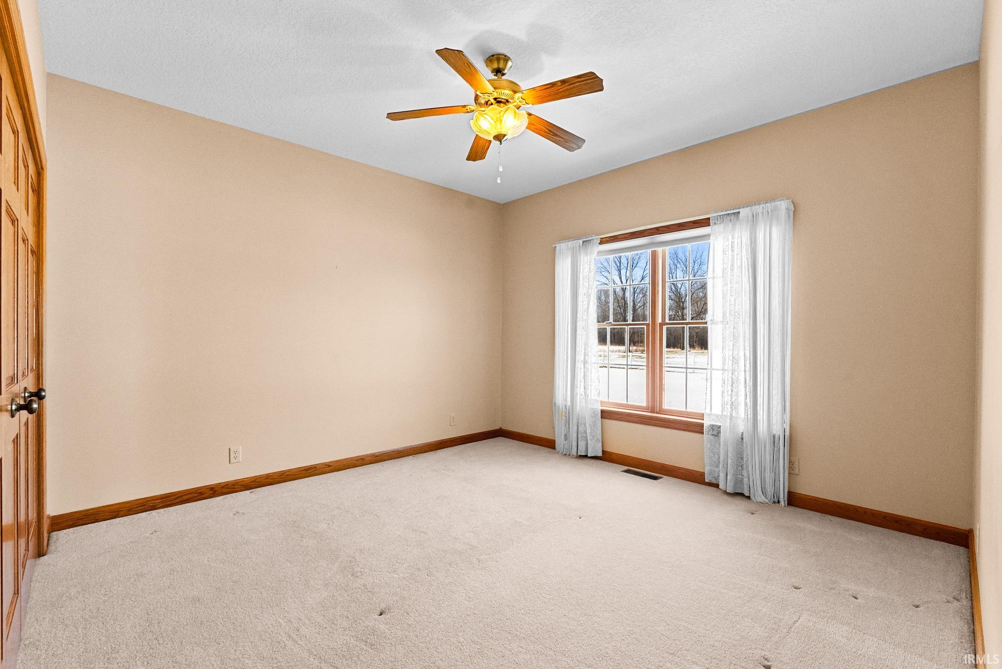 Spare room with light carpet and ceiling fan