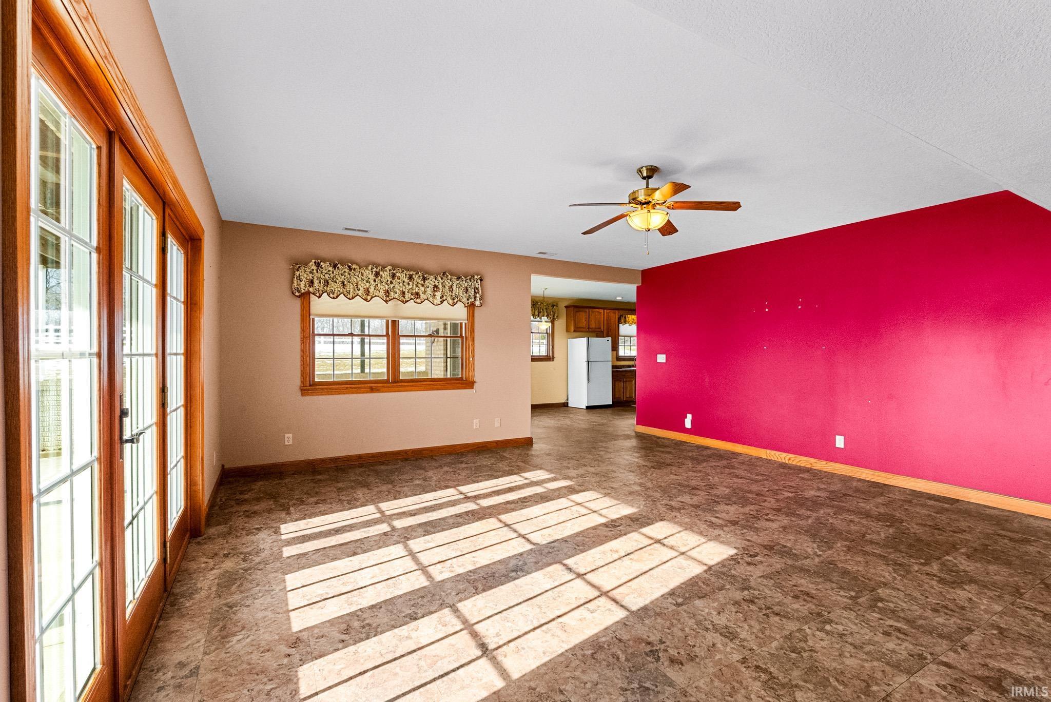 Unfurnished living room featuring baseboards and ceiling fan