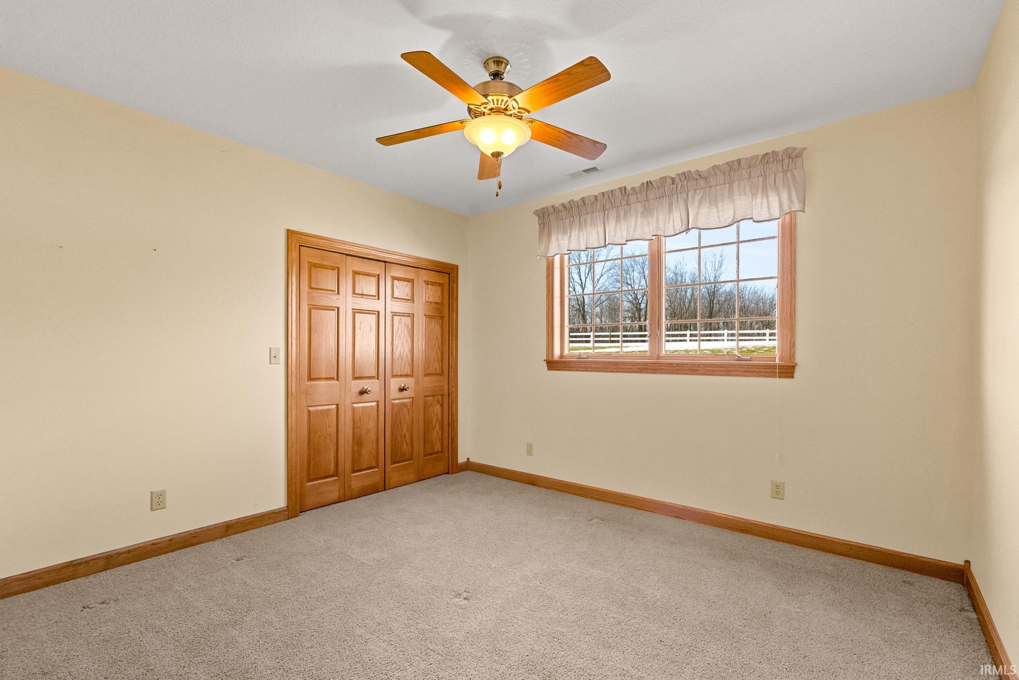 Unfurnished bedroom with carpet, a closet, and ceiling fan