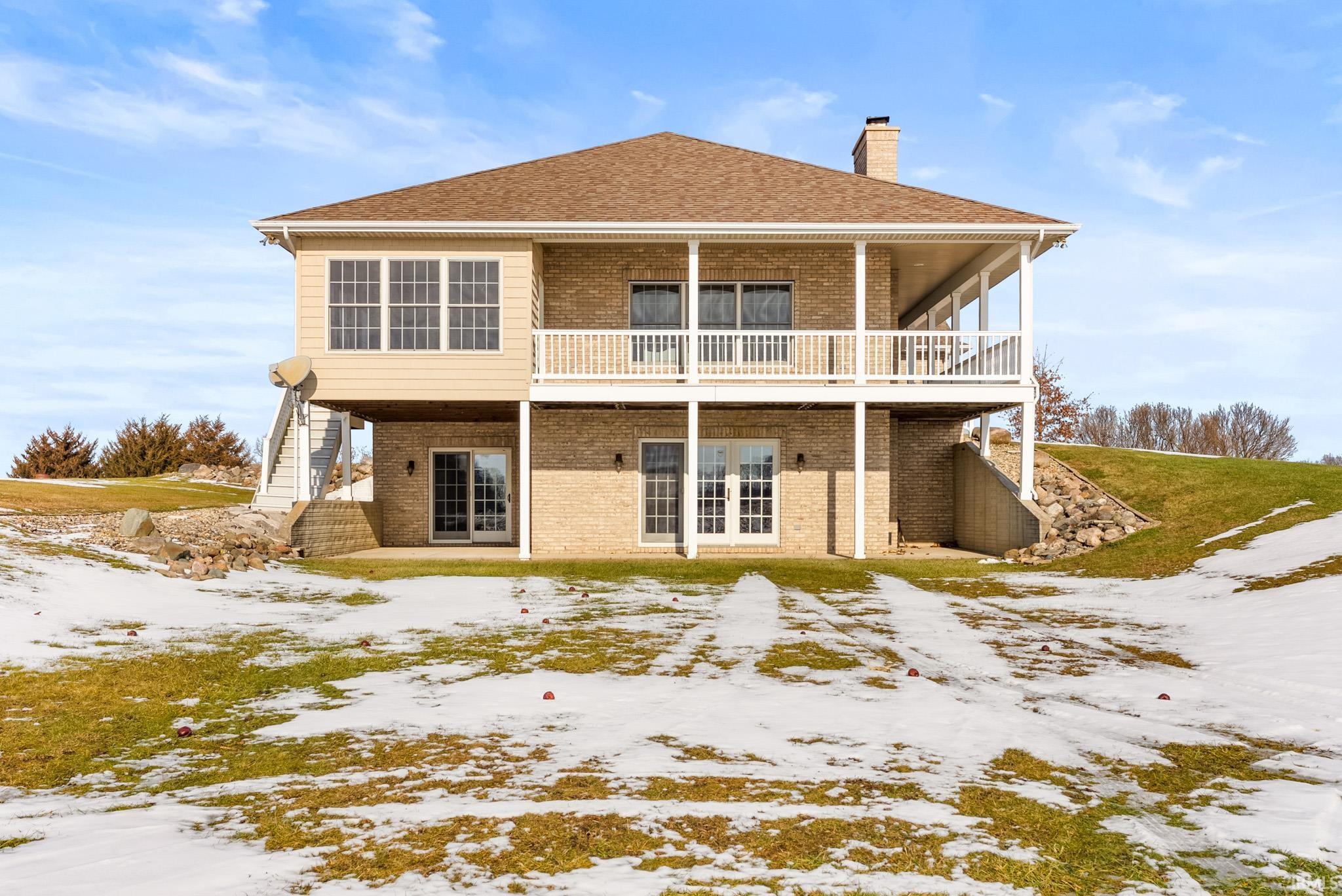 Back of house with stairway, a patio, brick siding, and french doors
