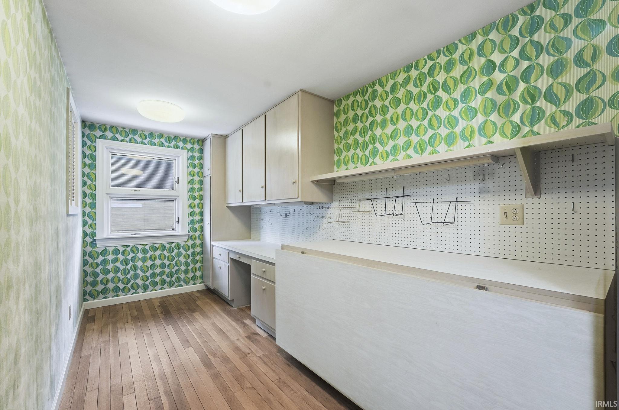 Washroom featuring wallpapered walls and dark wood-type flooring