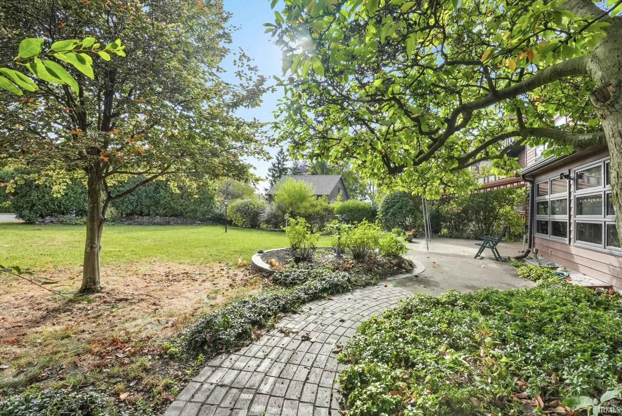 View of green lawn with a patio area