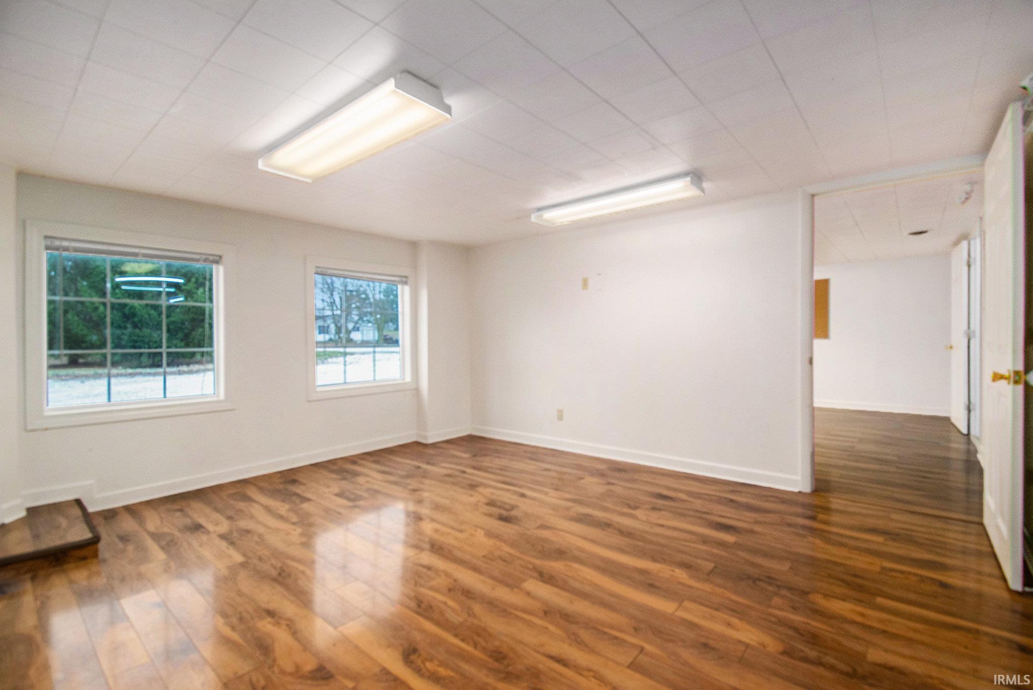 Spare room featuring dark wood-type flooring and baseboards