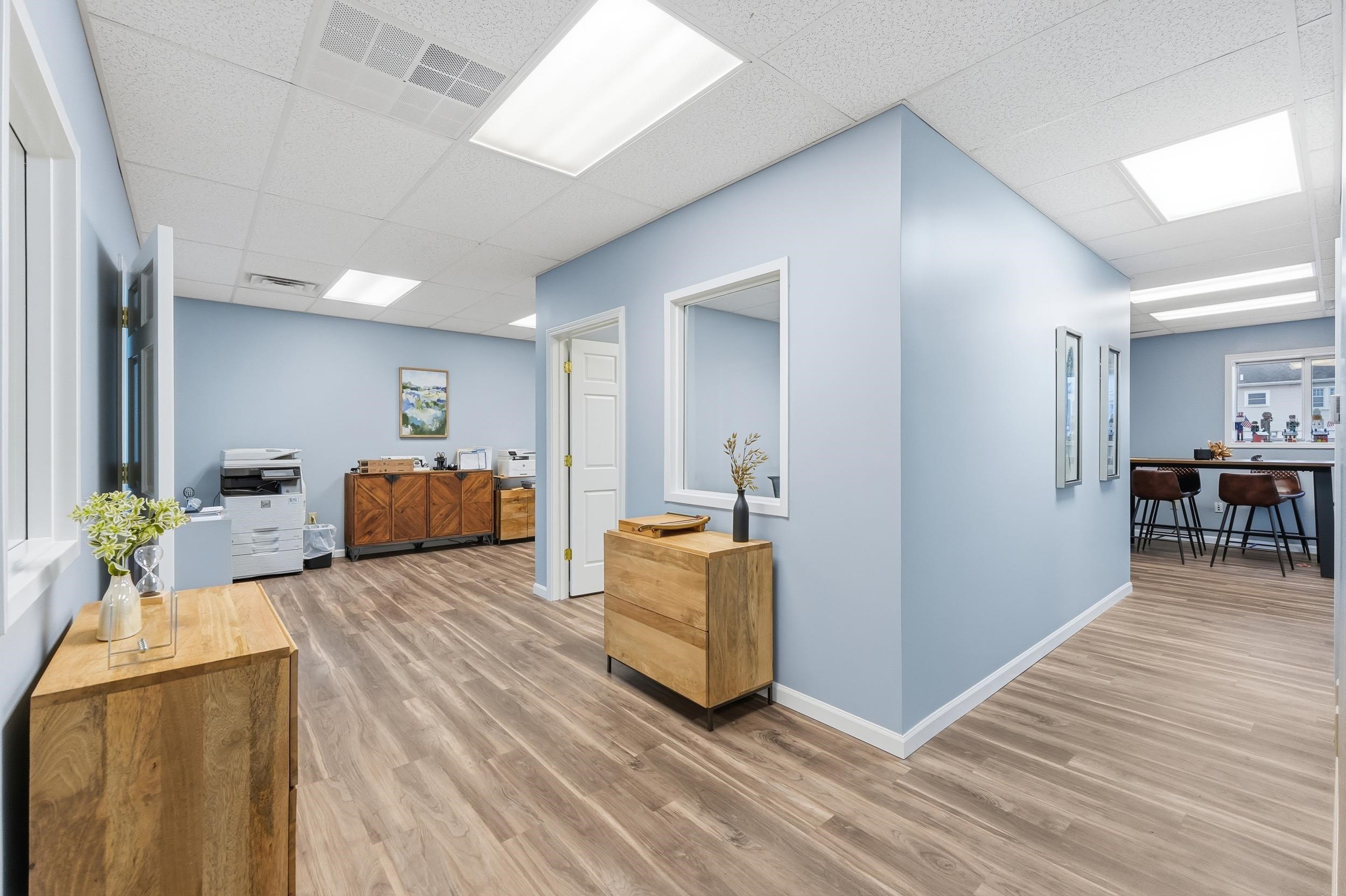 Hallway featuring light wood finished floors and a paneled ceiling