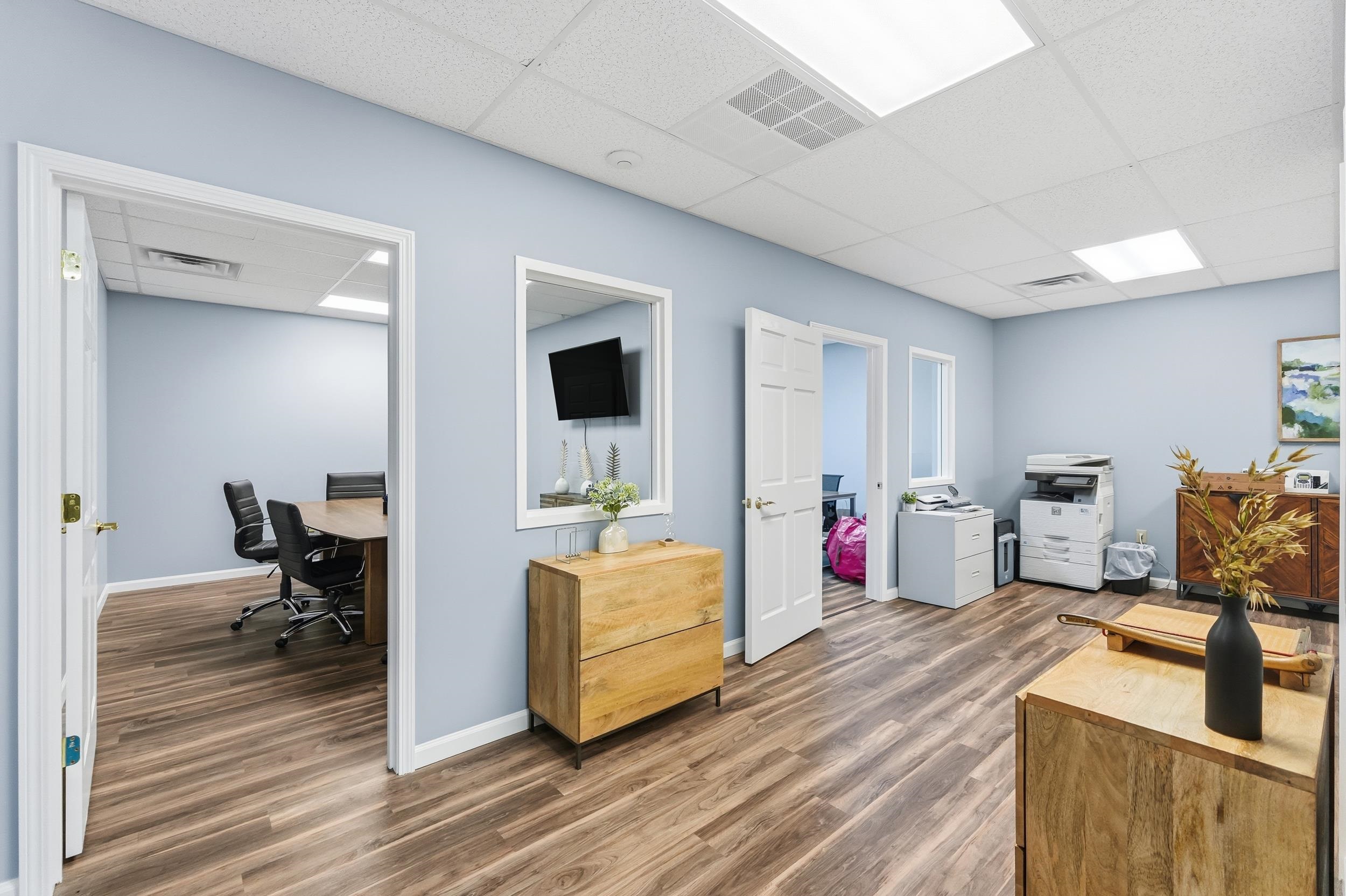 Office with a drop ceiling and dark wood finished floors
