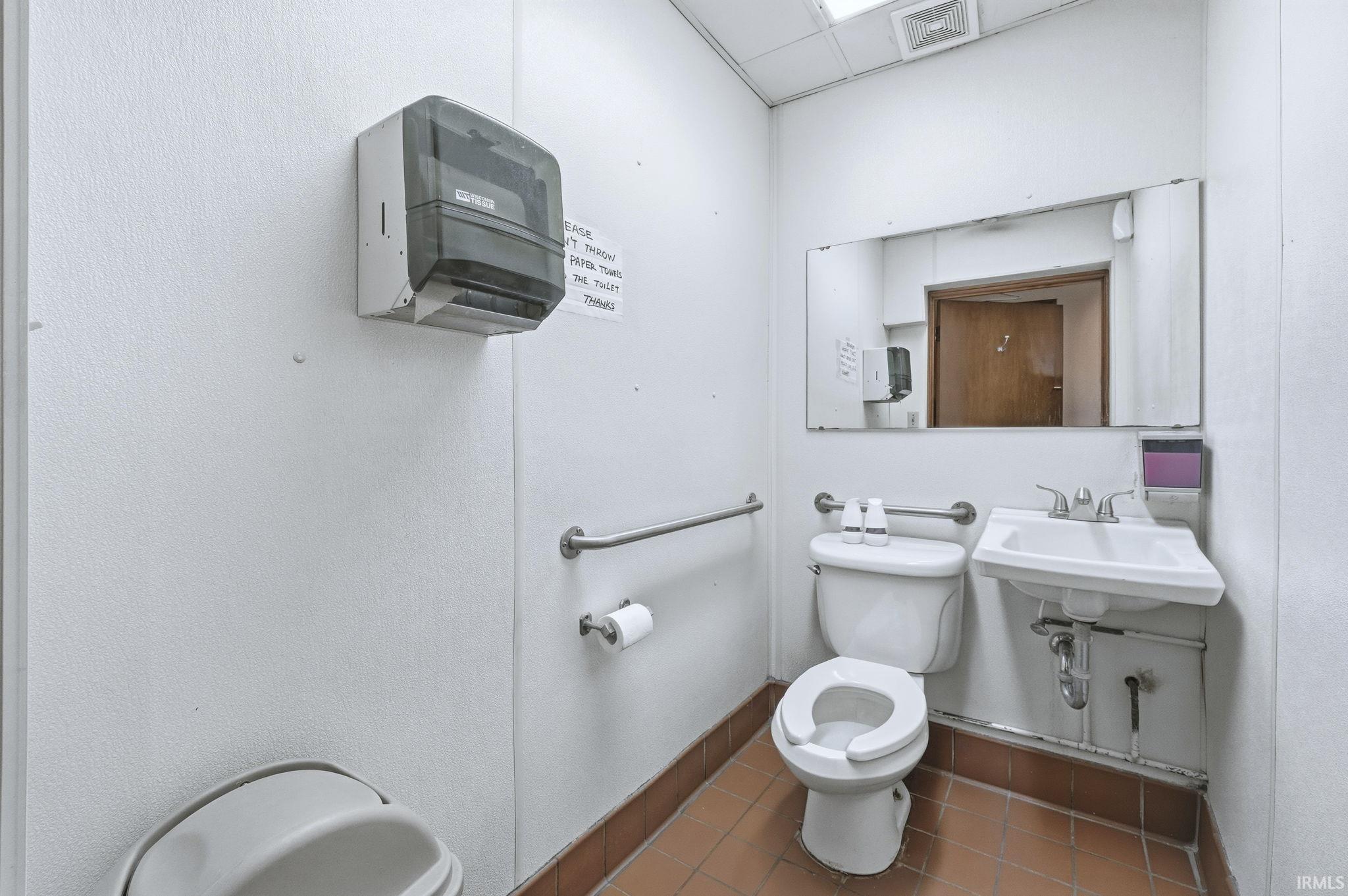 Half bath with toilet and a drop ceiling