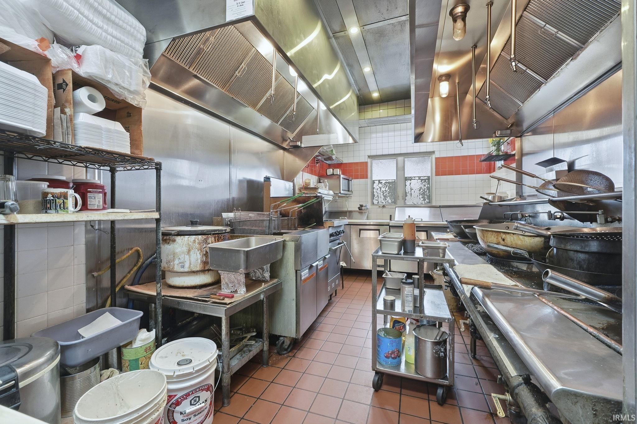 Kitchen featuring exhaust hood, stainless steel appliances, and wall chimney range hood
