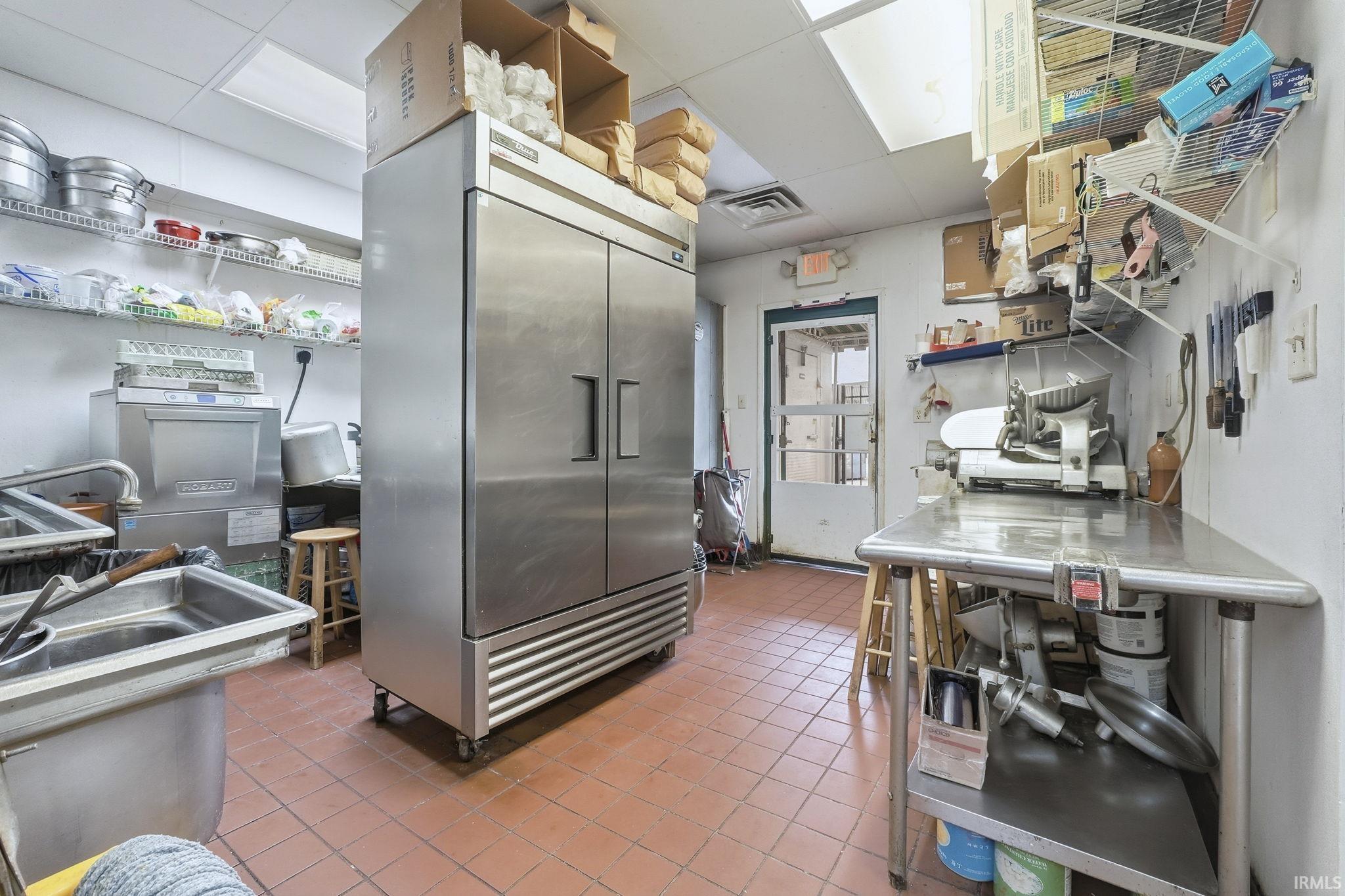 Kitchen featuring high end fridge, open shelves, and a drop ceiling