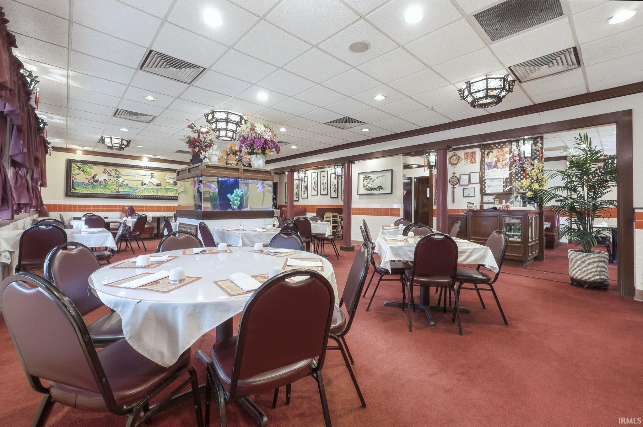 Dining room featuring a paneled ceiling, a wainscoted wall, carpet, and recessed lighting