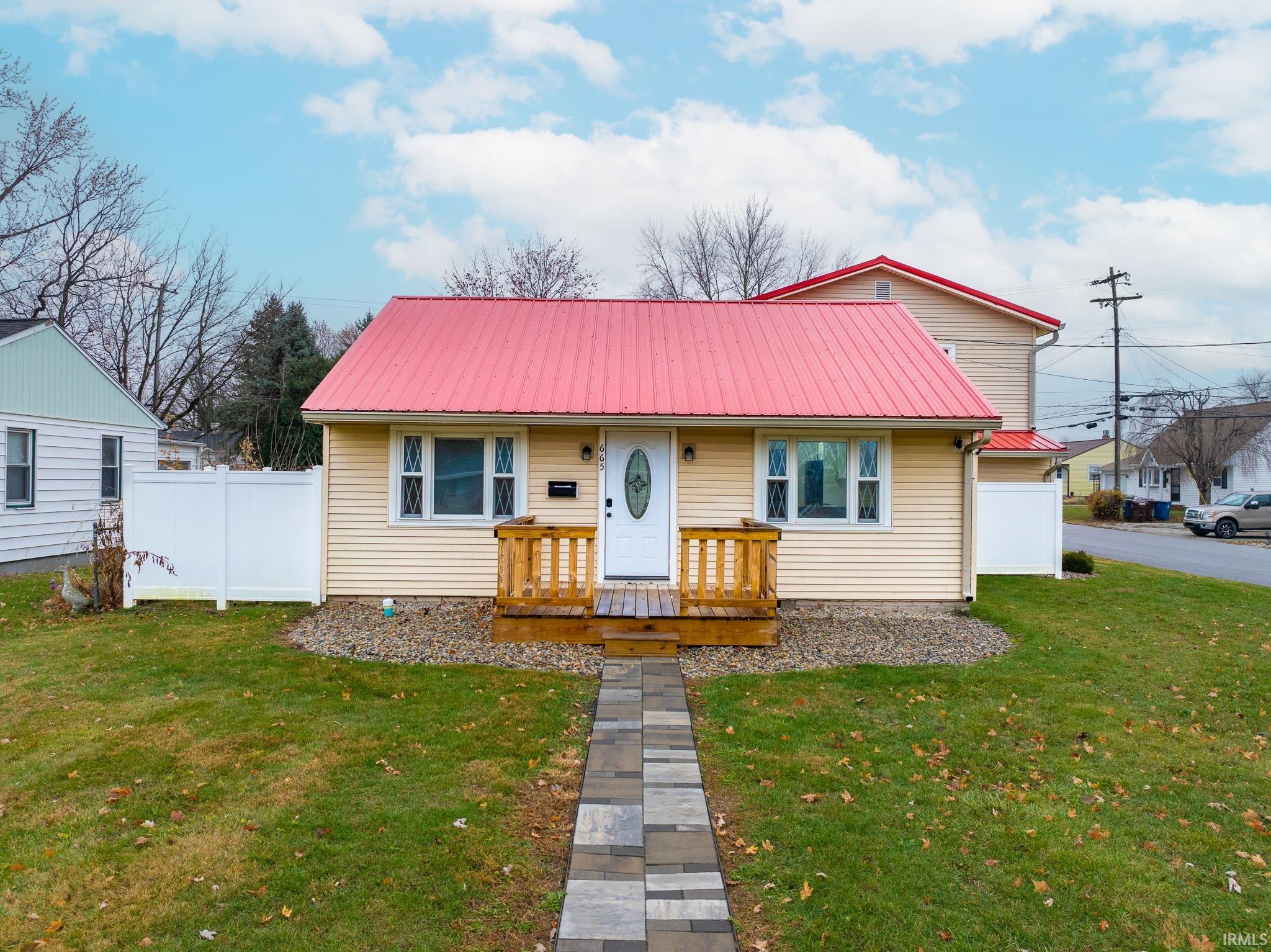 View of front of home featuring a metal roof and a wooden deck