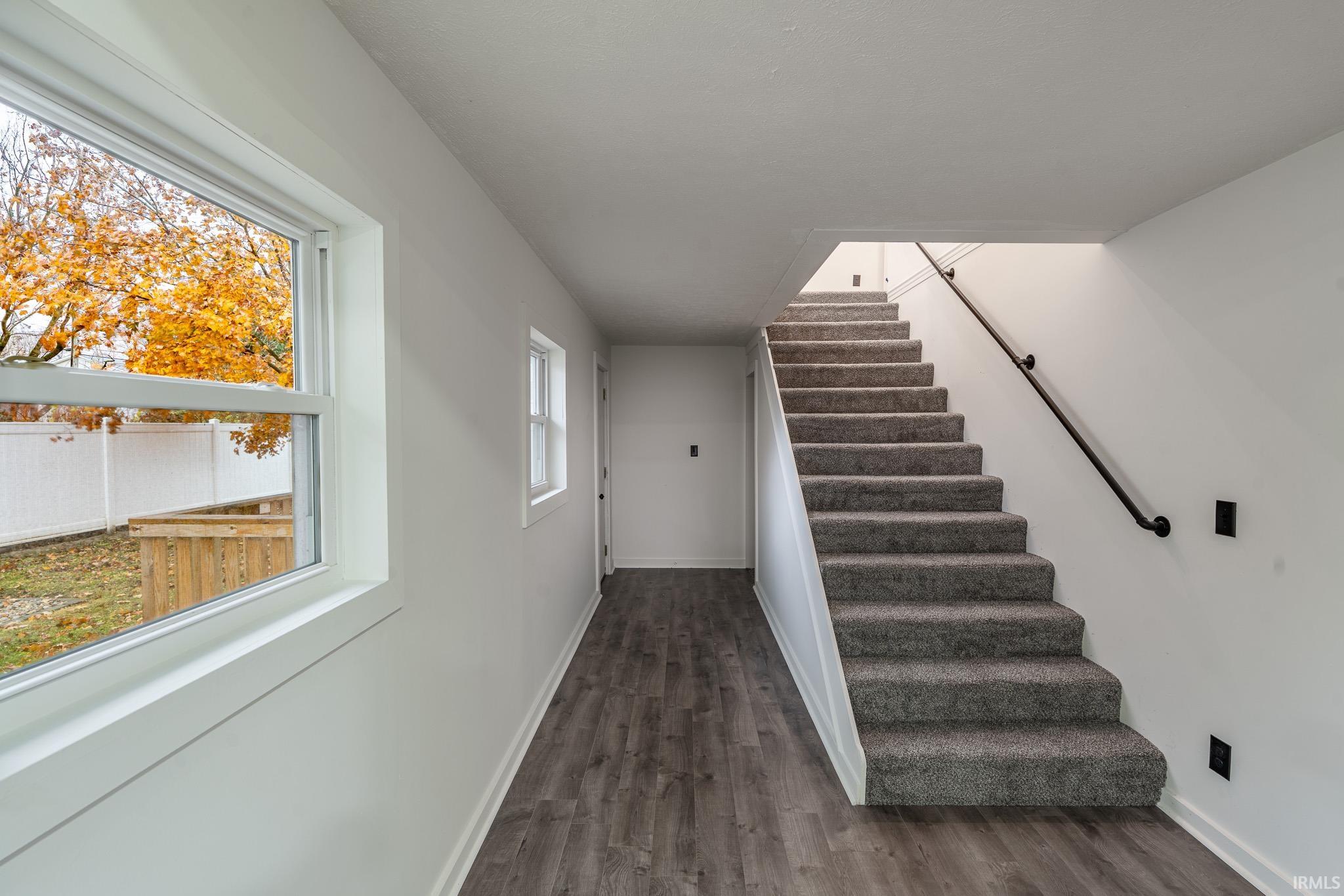 Stairs with wood finished floors and baseboards
