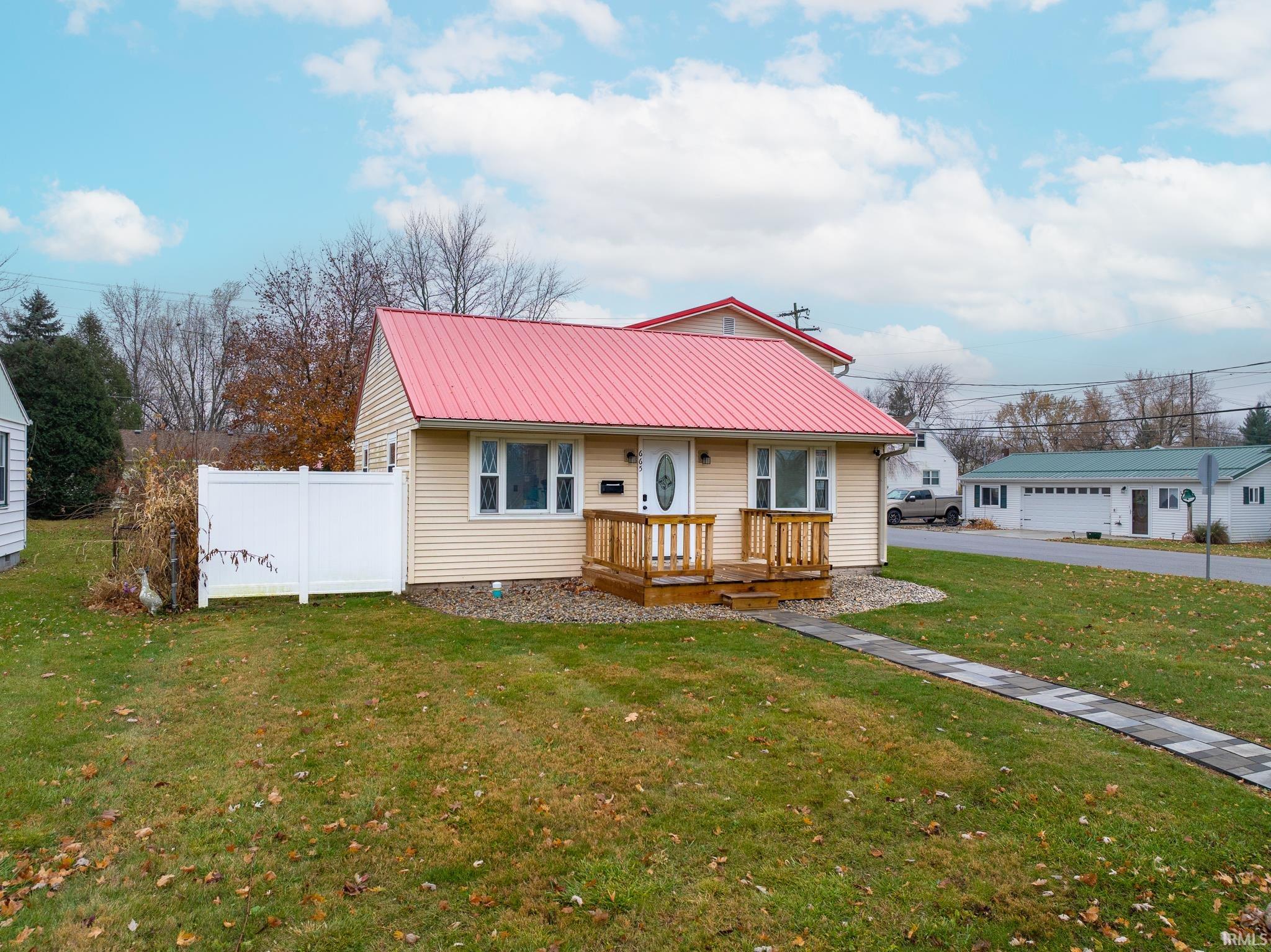 View of front of house with a deck and a metal roof