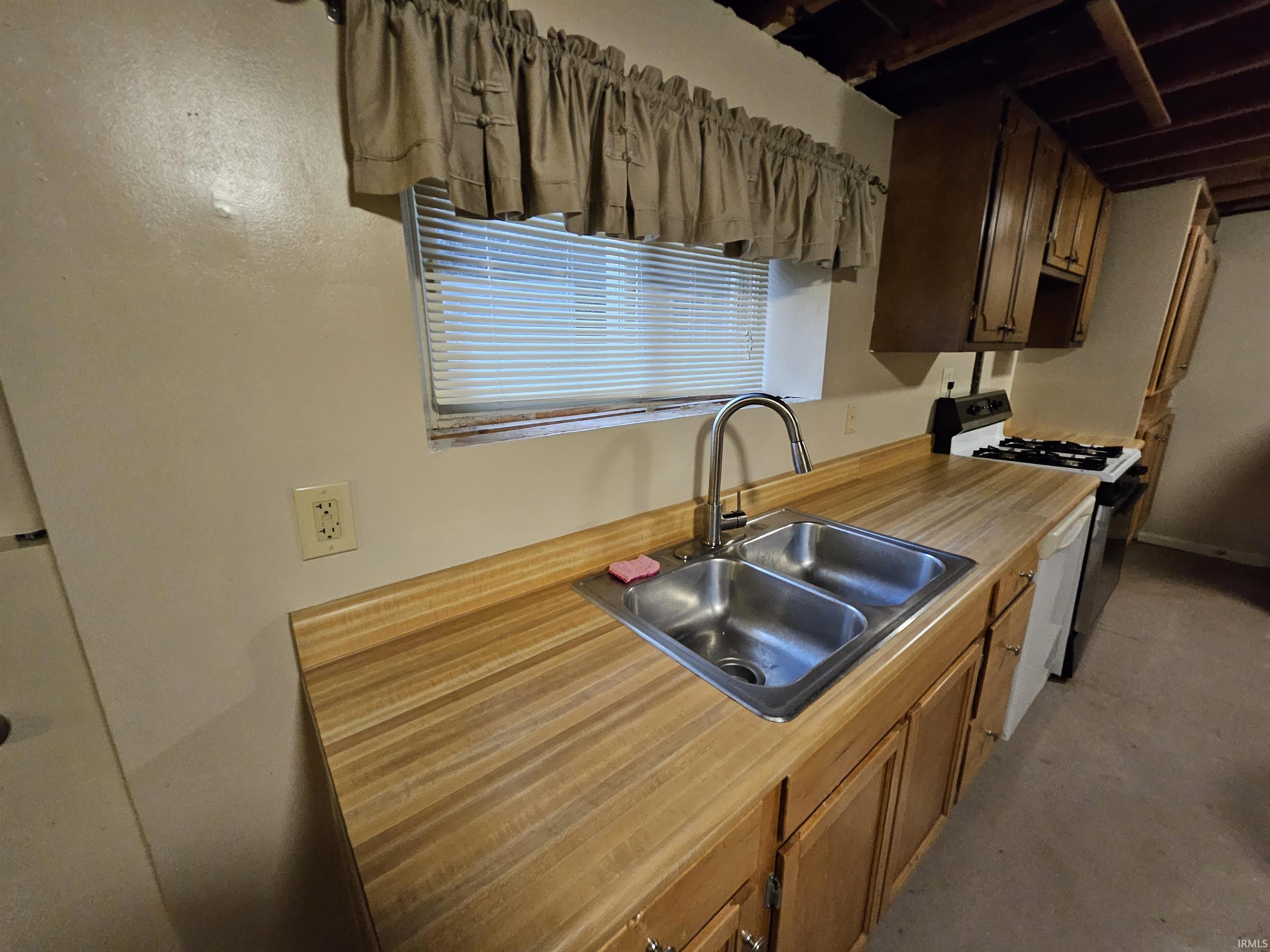 Kitchen with range with gas cooktop, light countertops, and dark brown cabinets