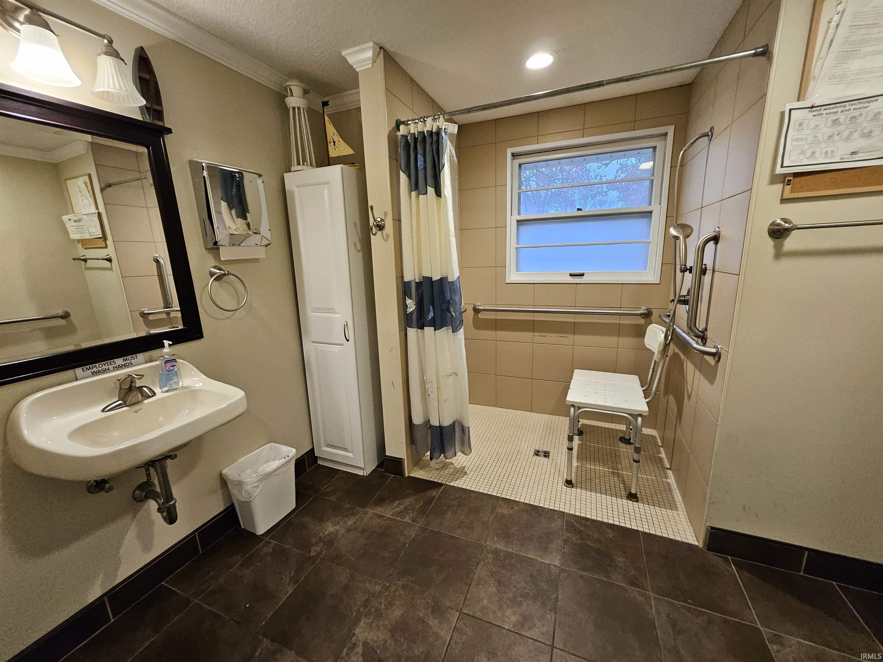 Full bathroom featuring ornamental molding, a stall shower, and a textured ceiling