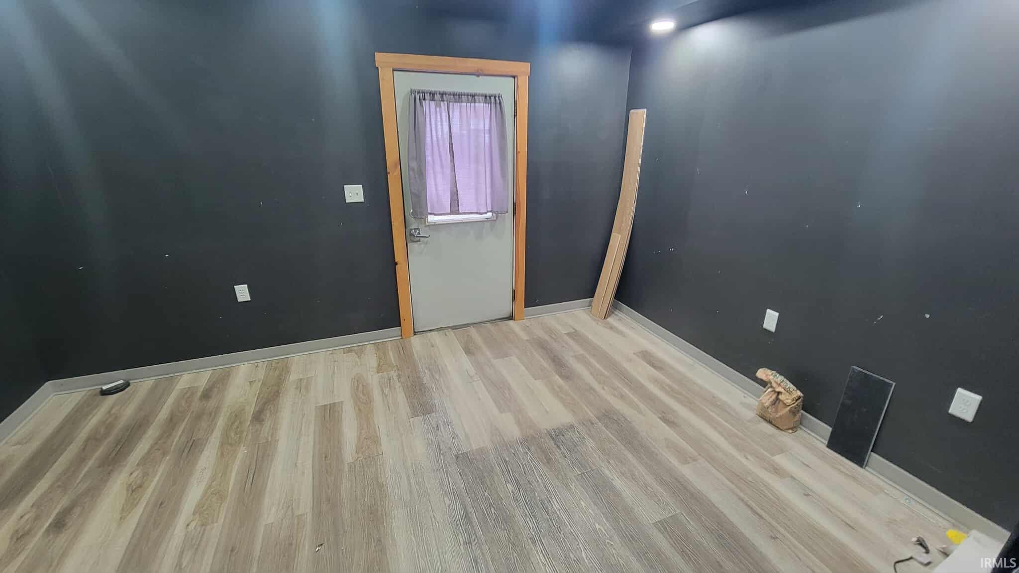 Spare room featuring baseboards and light wood-style flooring