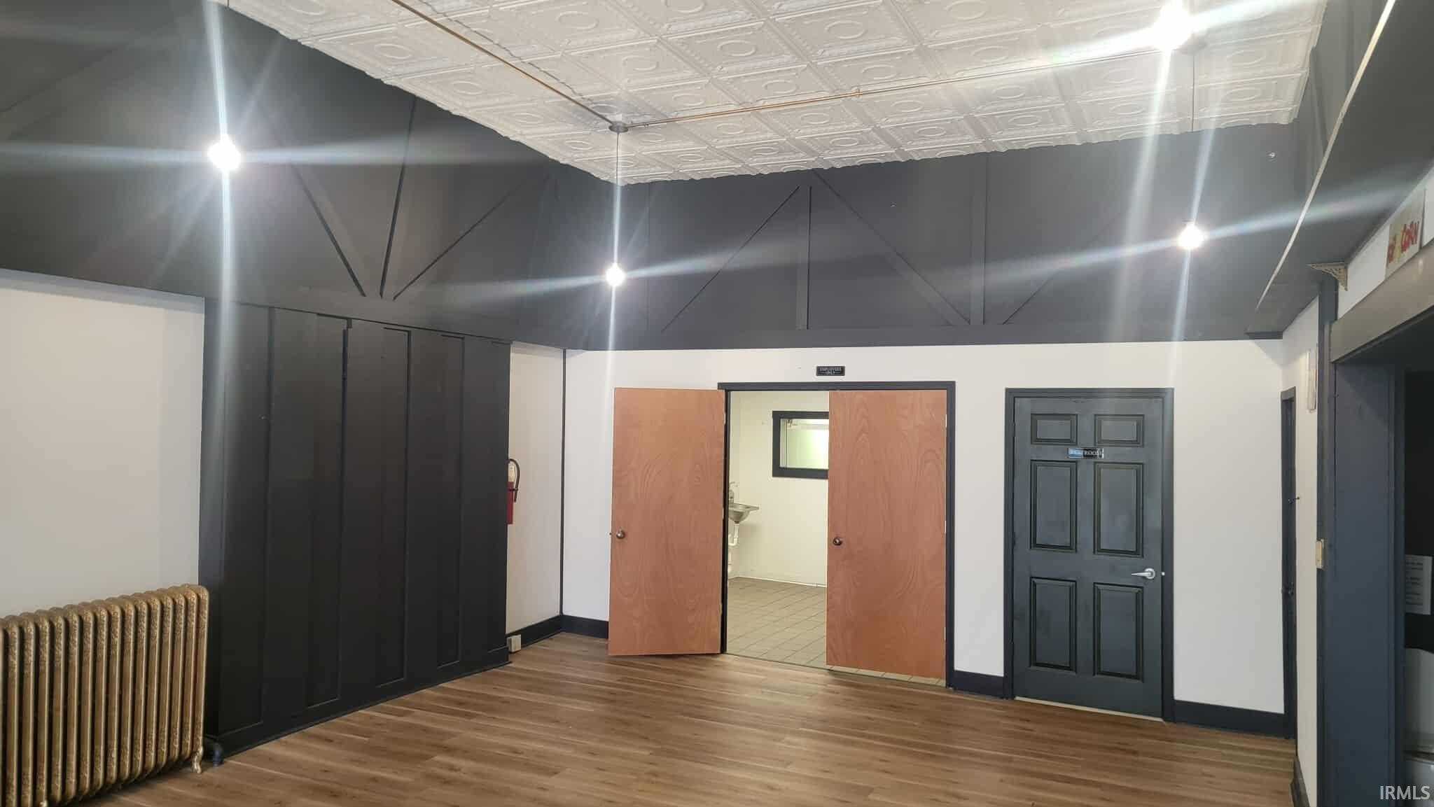 Spare room featuring radiator heating unit, an ornate ceiling, and wood finished floors