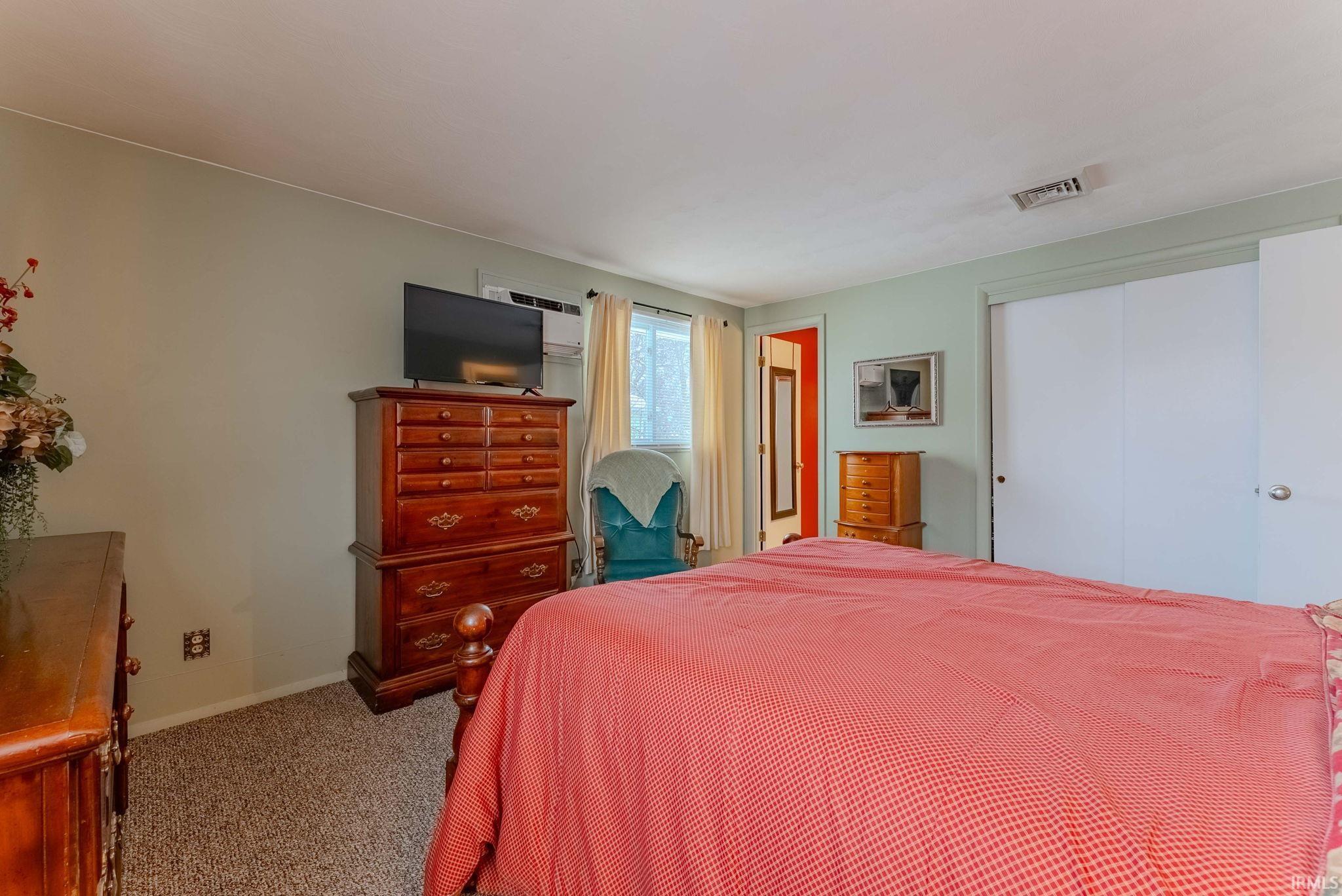 Carpeted bedroom with a closet and baseboards