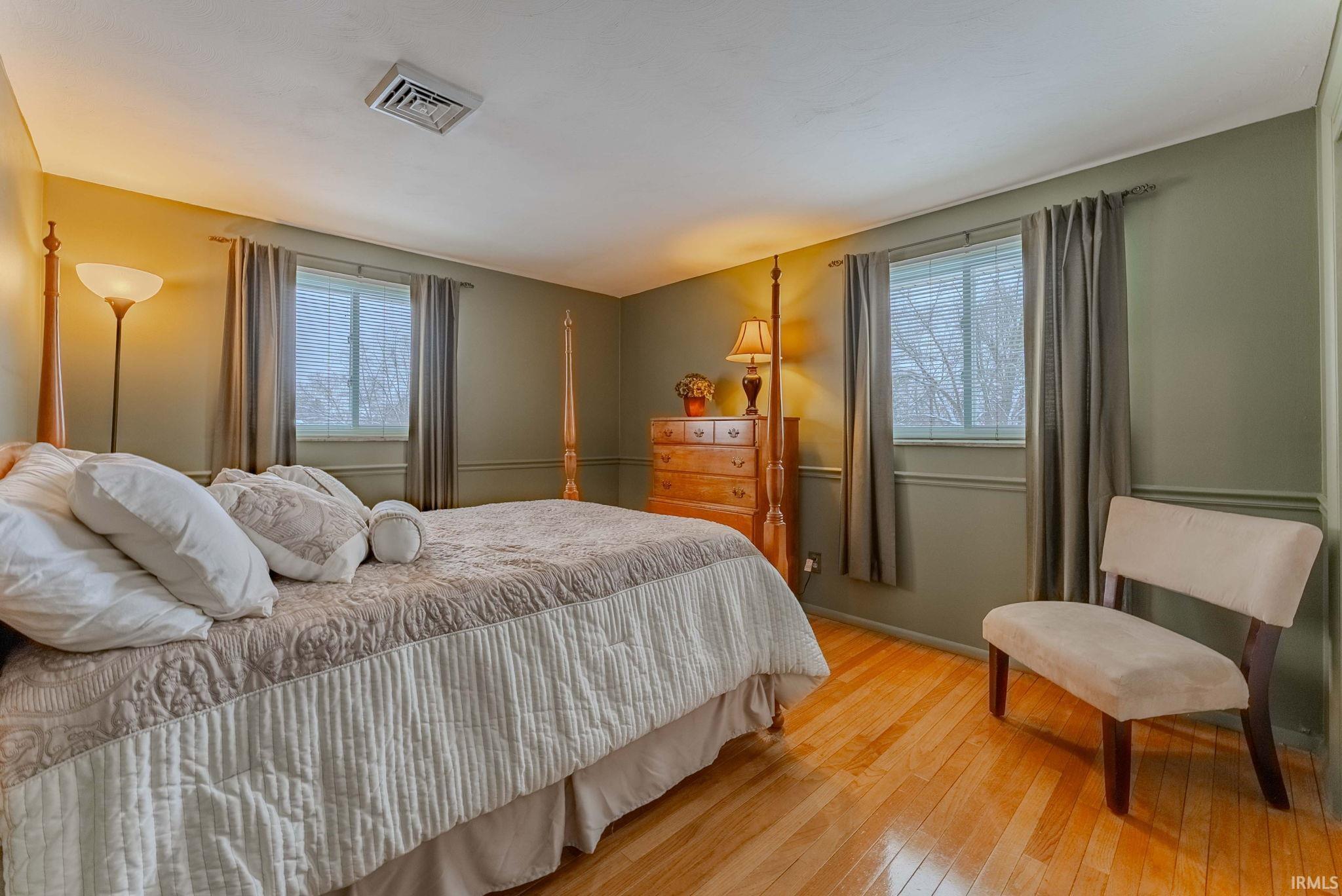 Bedroom featuring hardwood / wood-style flooring and multiple windows