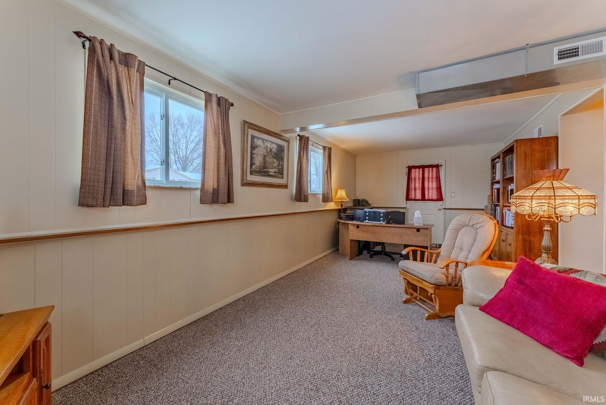 Office space with carpet flooring and wood walls