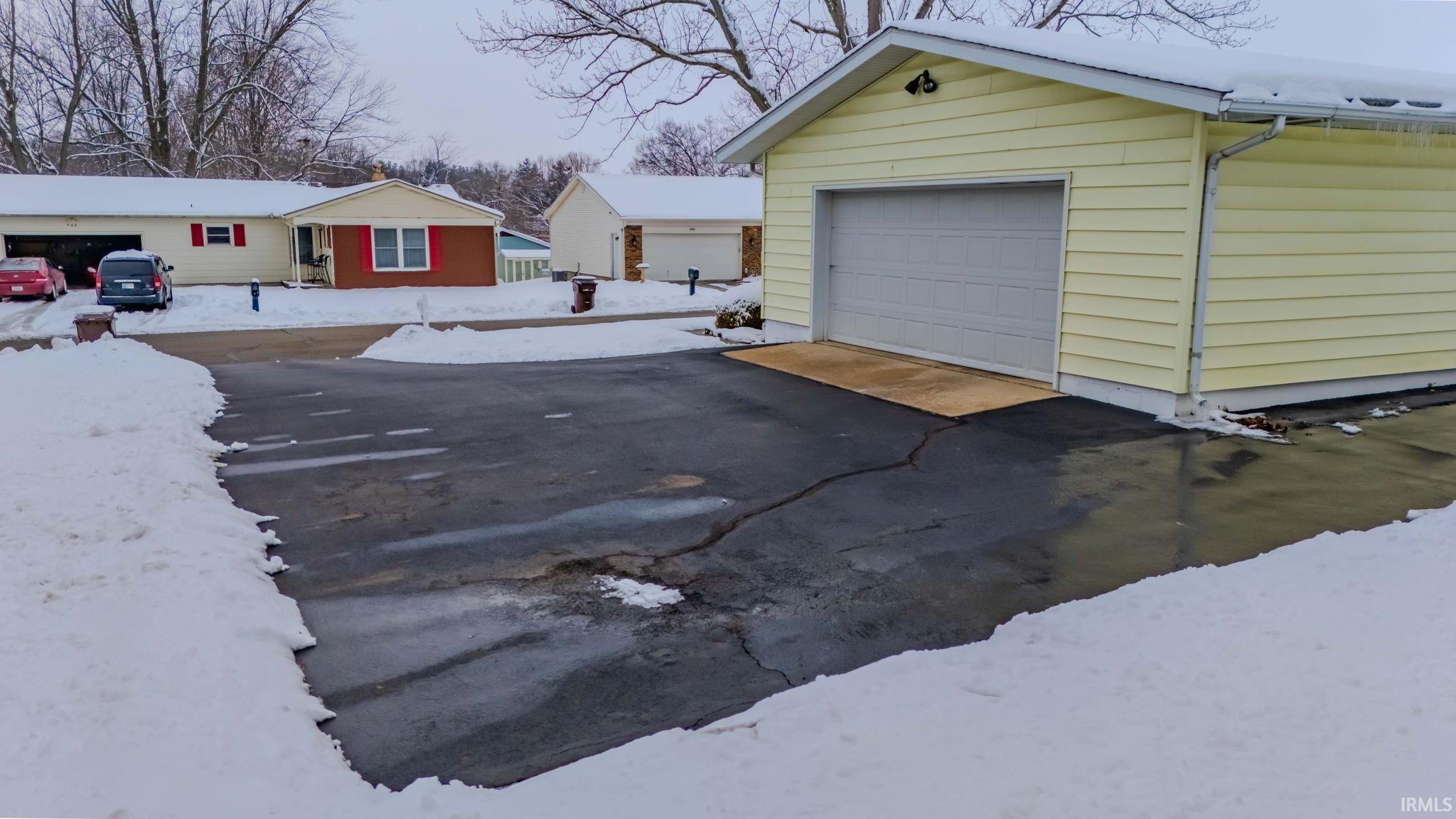 Snow covered garage with a garage
