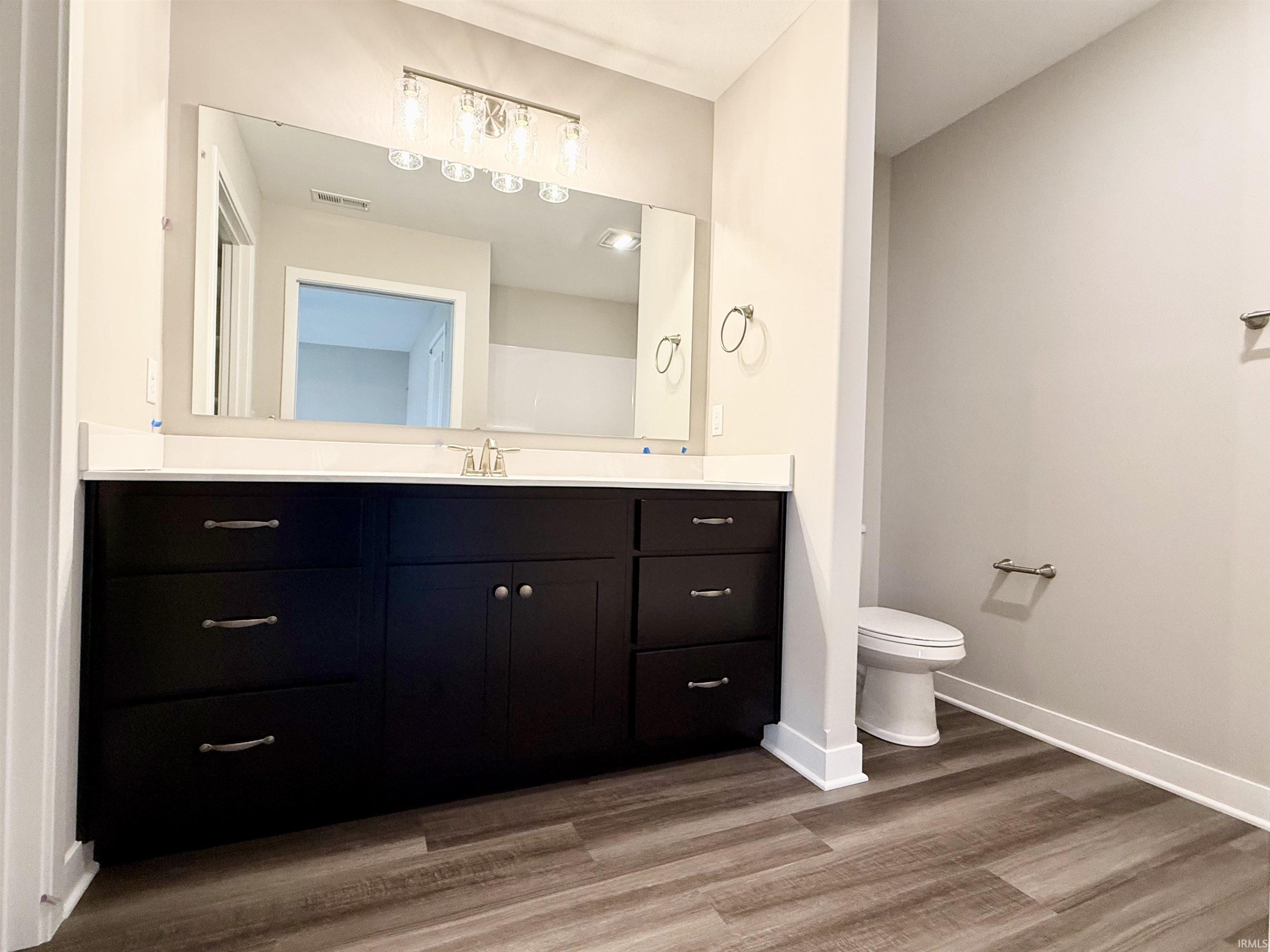 Full bathroom with vanity and light wood finished floors