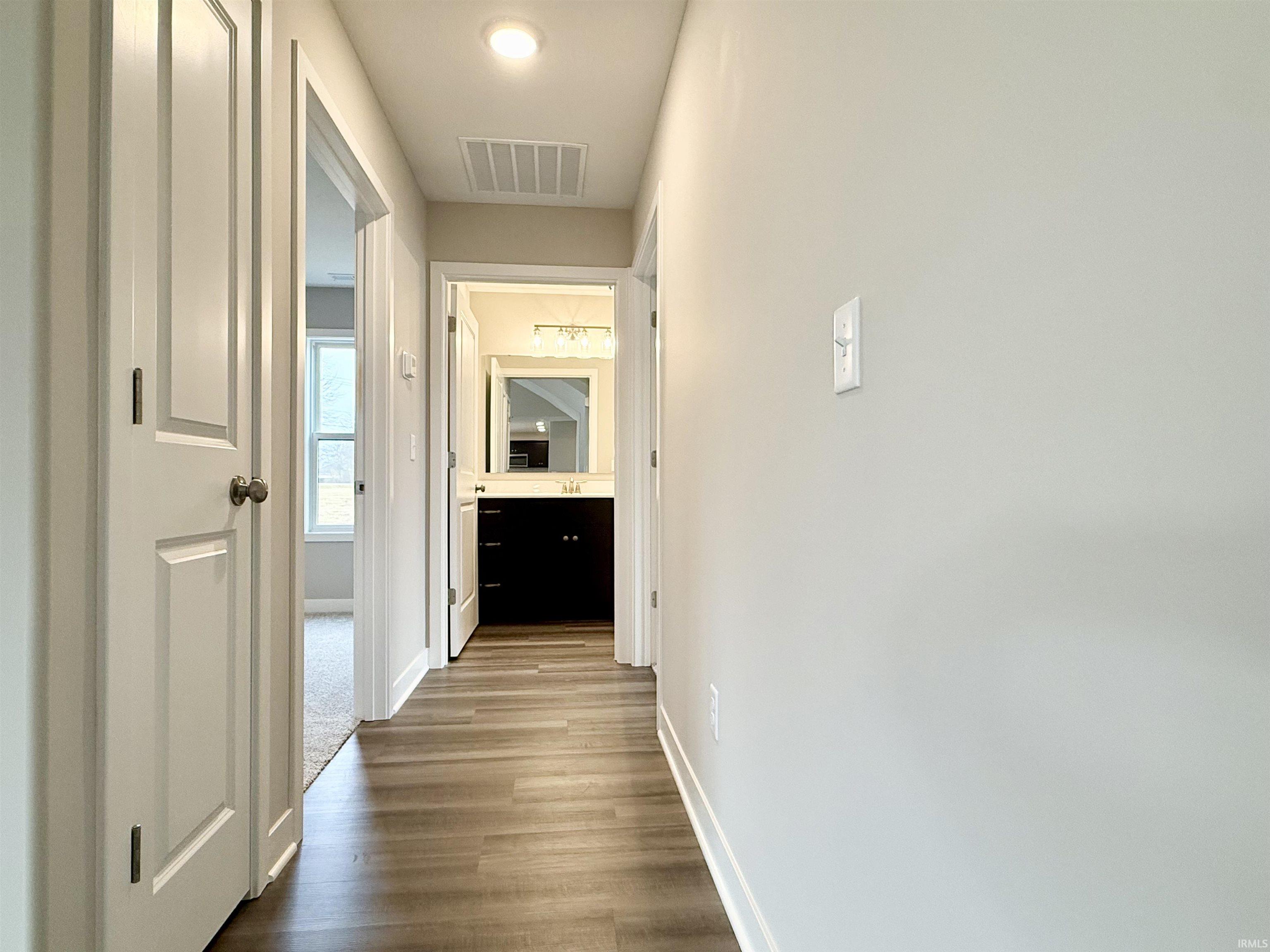 Hallway featuring baseboards and dark wood-style floors