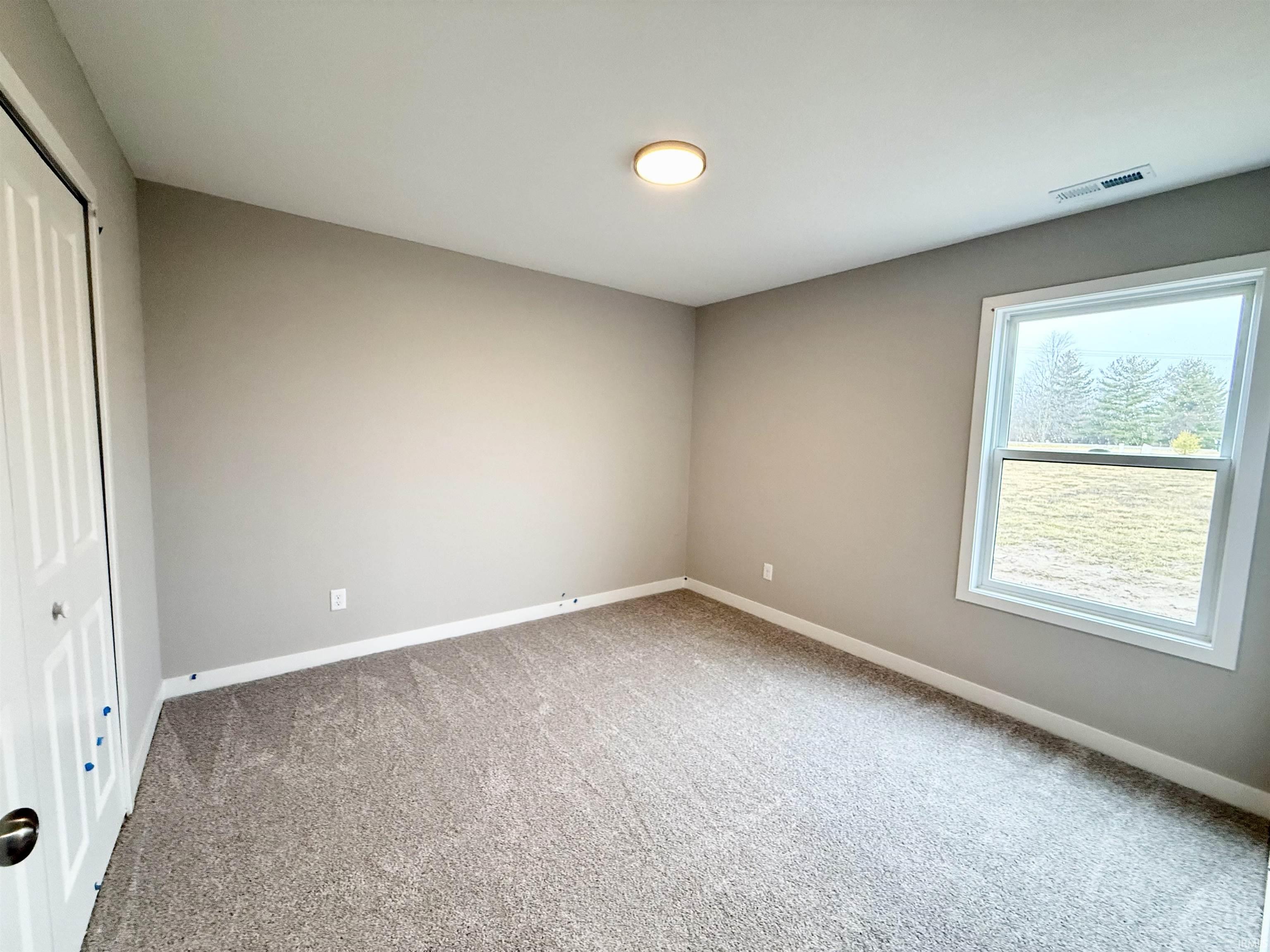 Unfurnished bedroom featuring a closet and light carpet