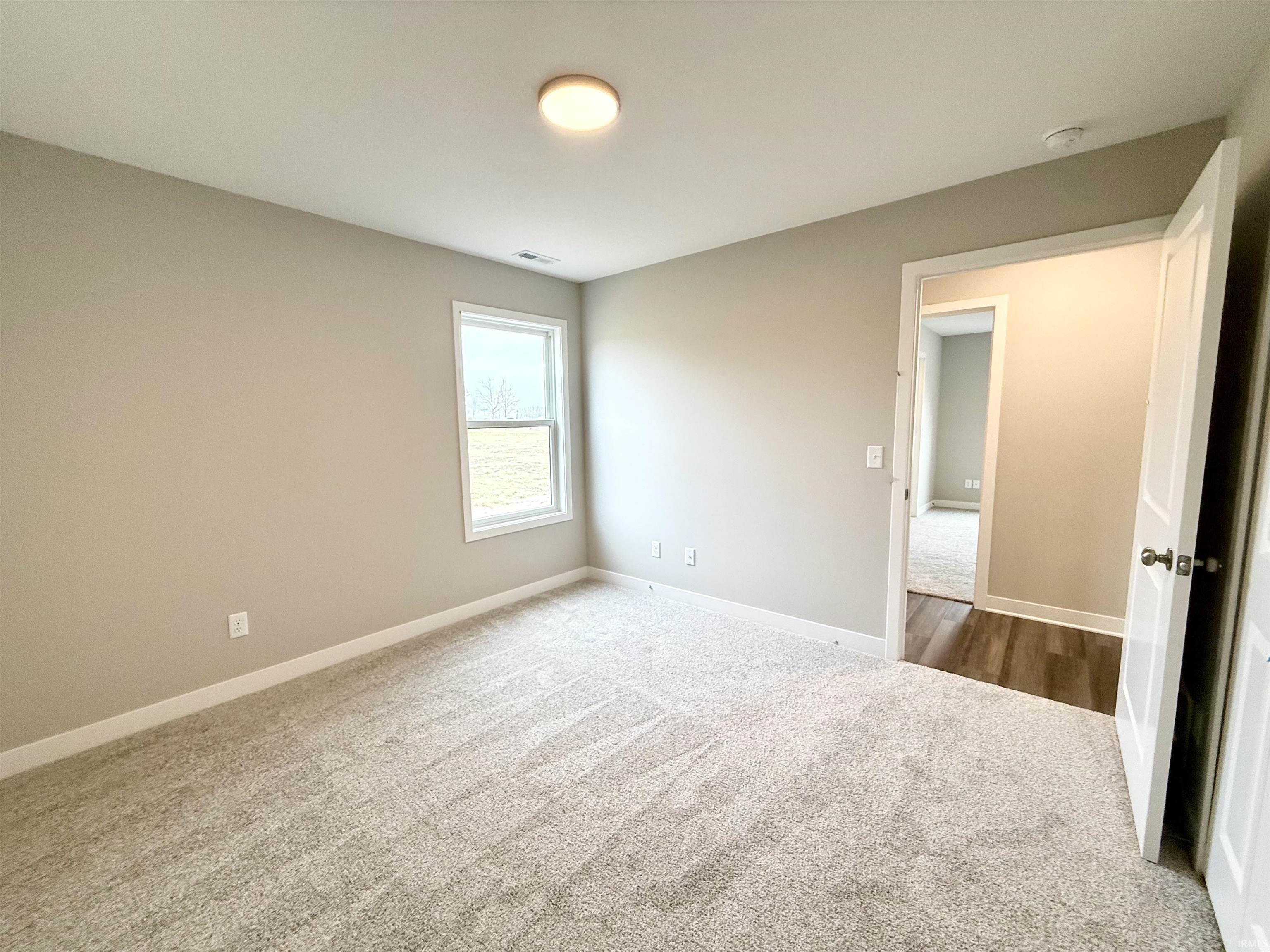Carpeted spare room with baseboards