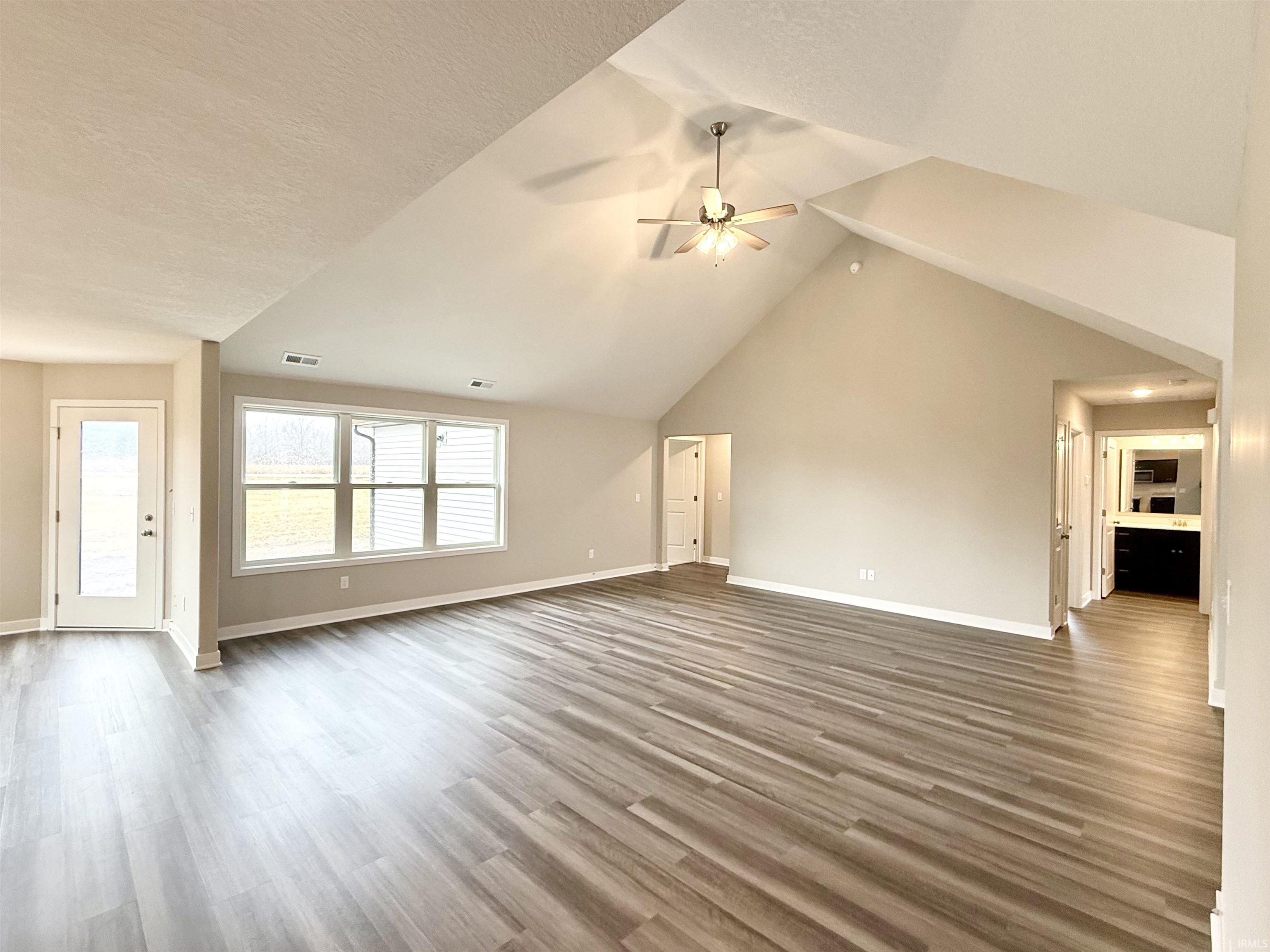 Unfurnished living room featuring a ceiling fan and light wood-type flooring