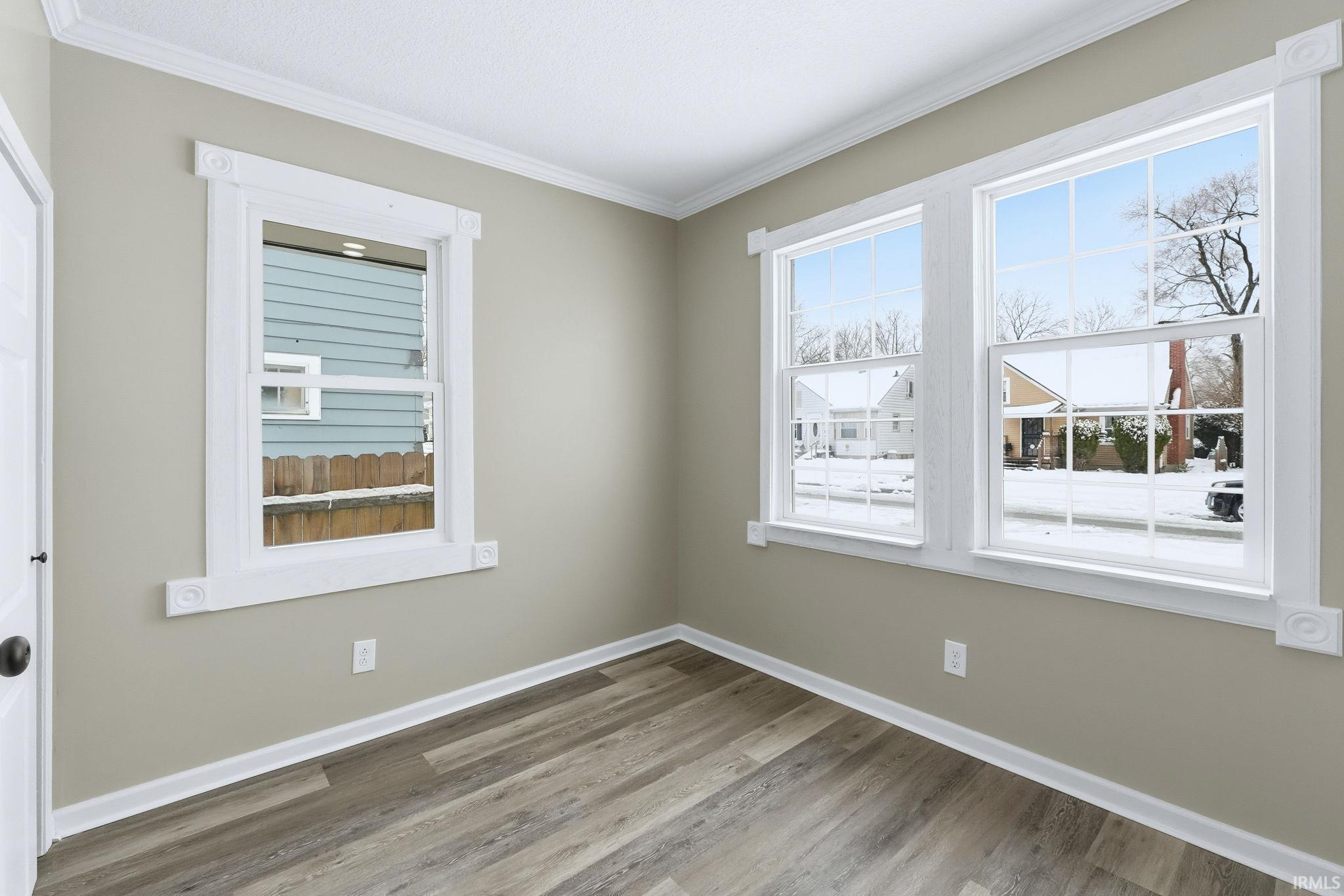 Empty room with light wood-style floors and ornamental molding