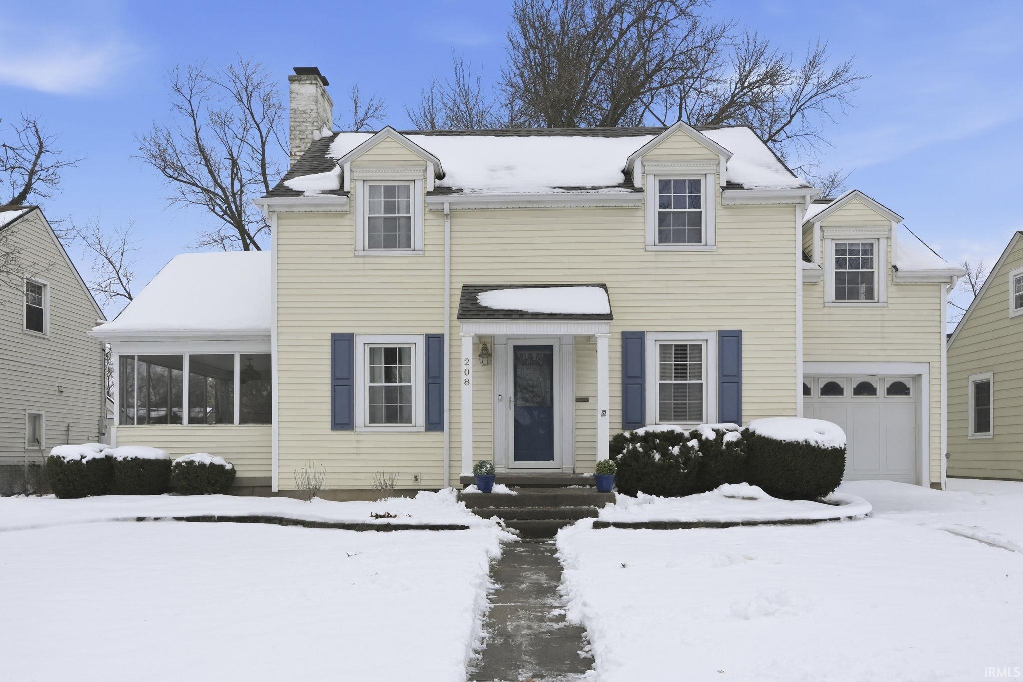 View of front of home with a chimney and a garage