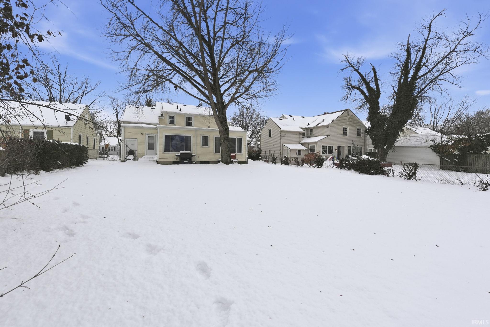 Snow covered property with a patio