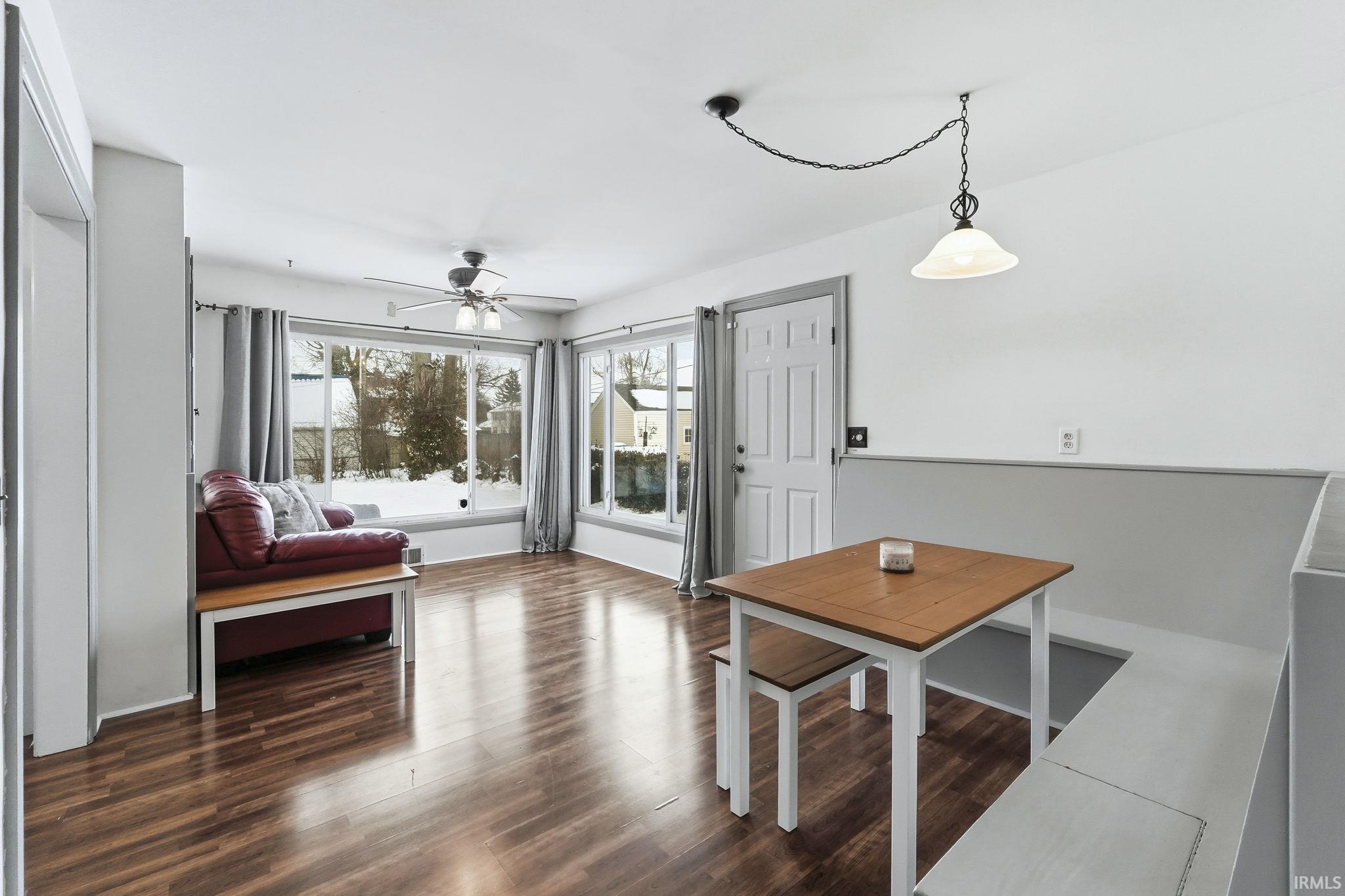 Dining room with dark wood finished floors and ceiling fan