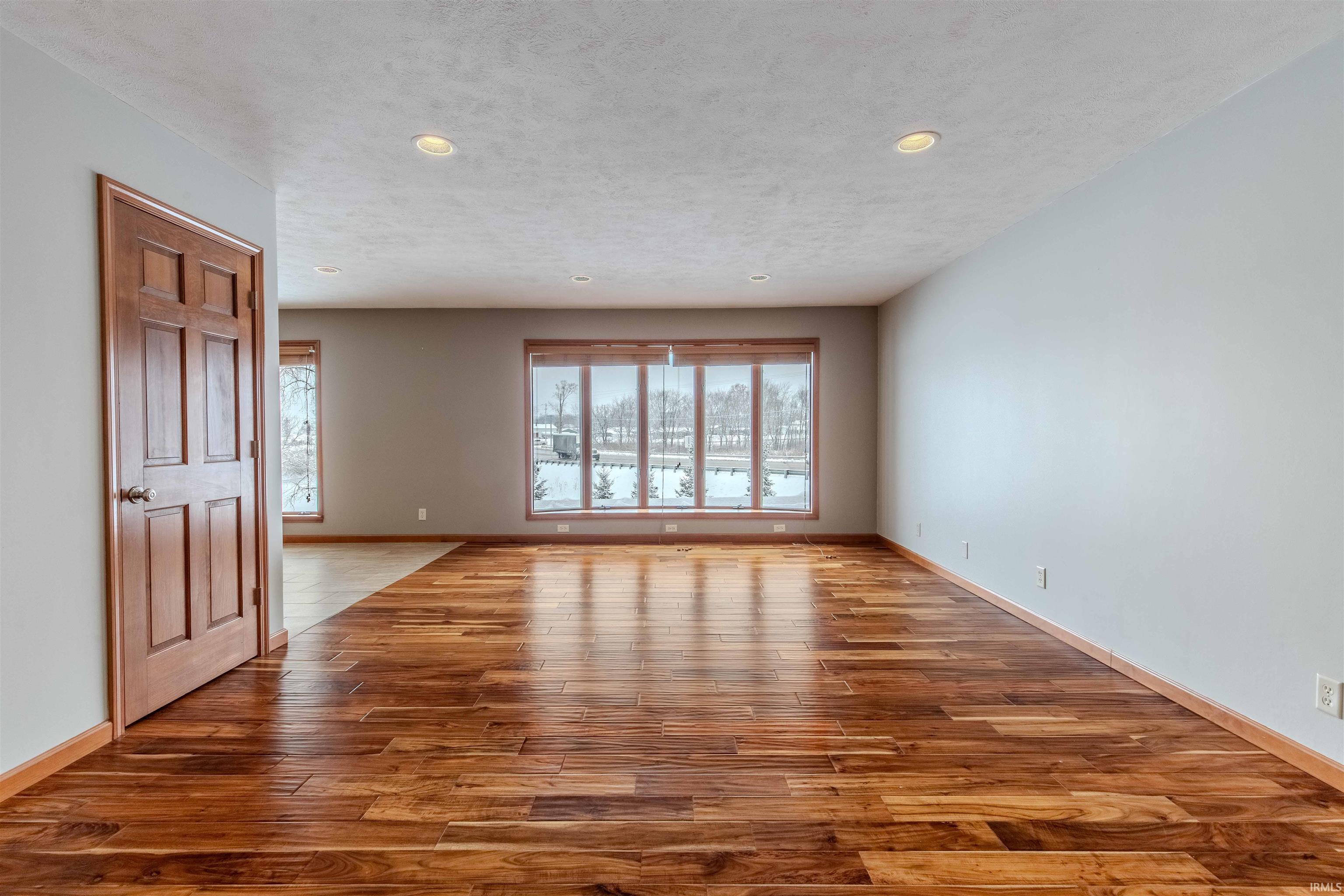 Unfurnished room with light wood-type flooring, recessed lighting, and a textured ceiling
