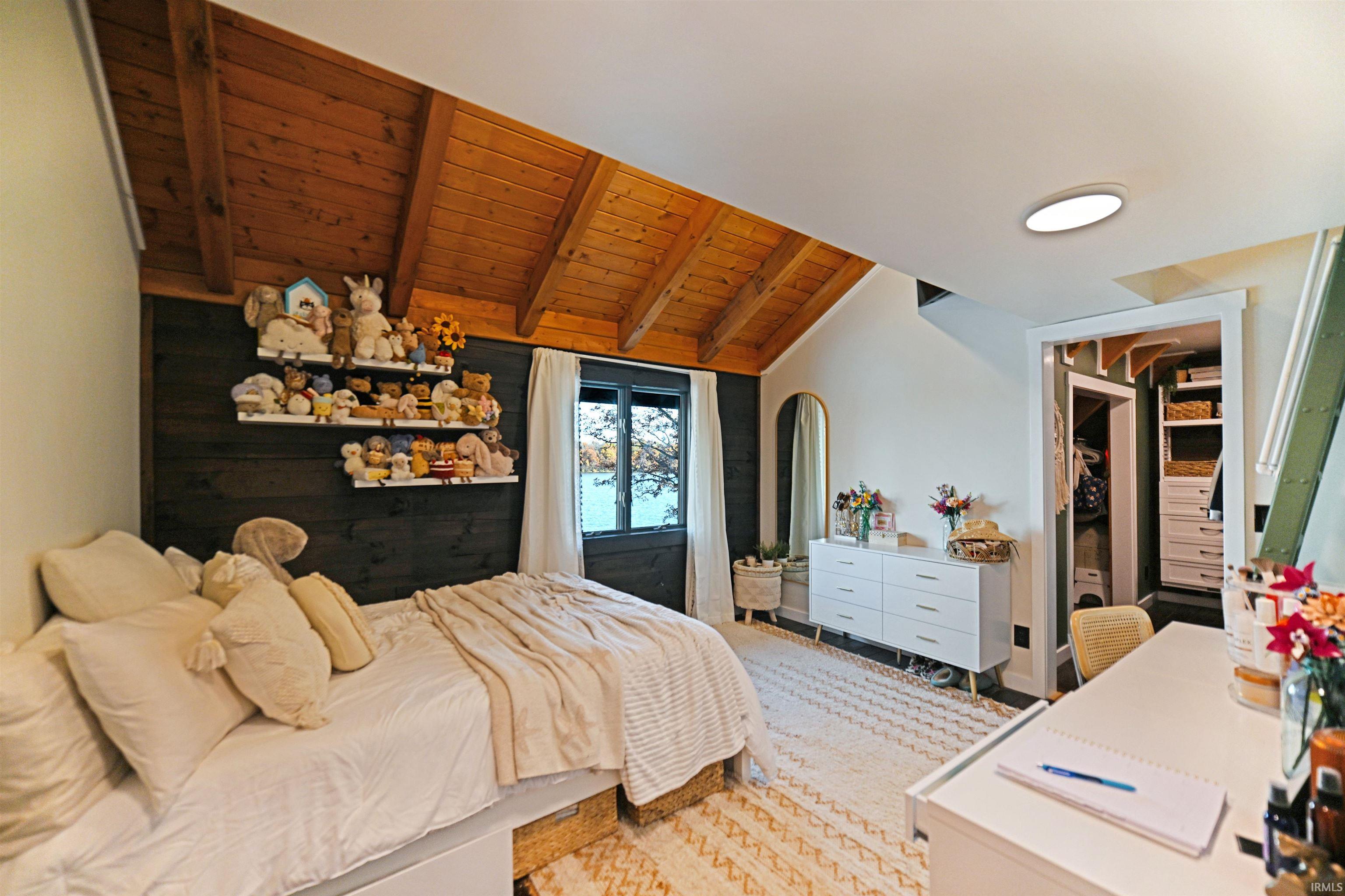 Bedroom featuring a walk in closet and wood ceiling