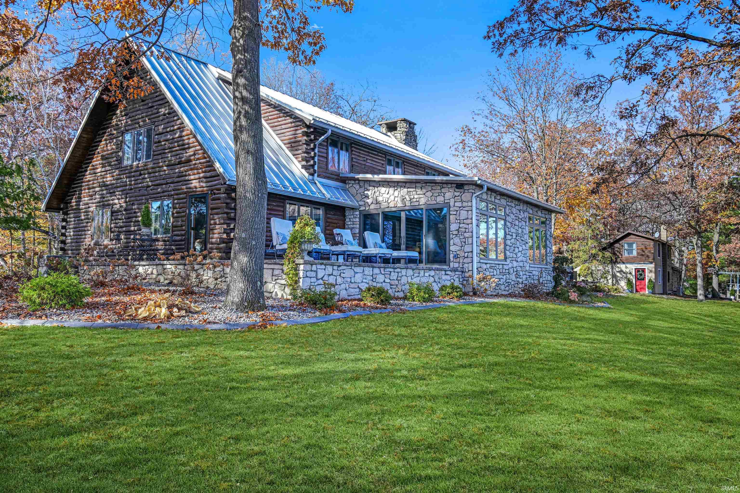 Back of property featuring a chimney, a patio area, and a yard