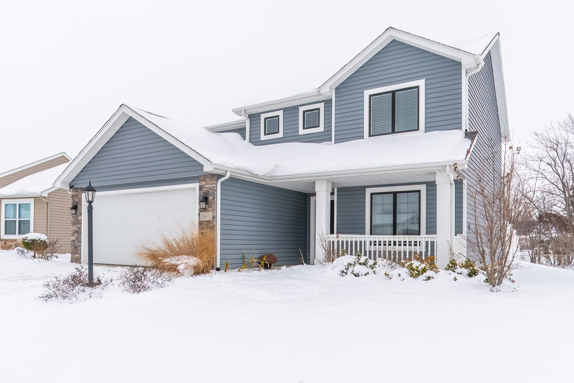 Traditional-style house with a porch and an attached garage